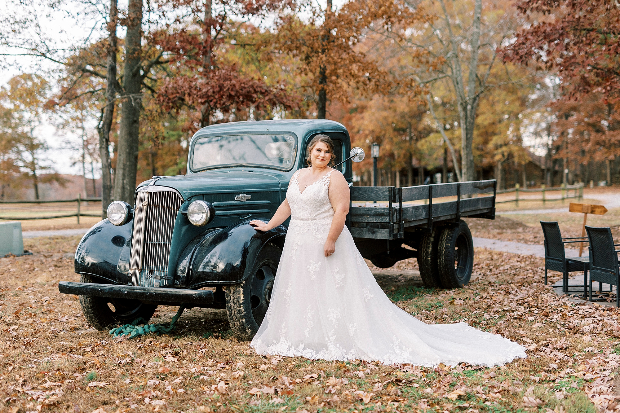 bride stands by vintage blue truck at the Farm at Brusharbor