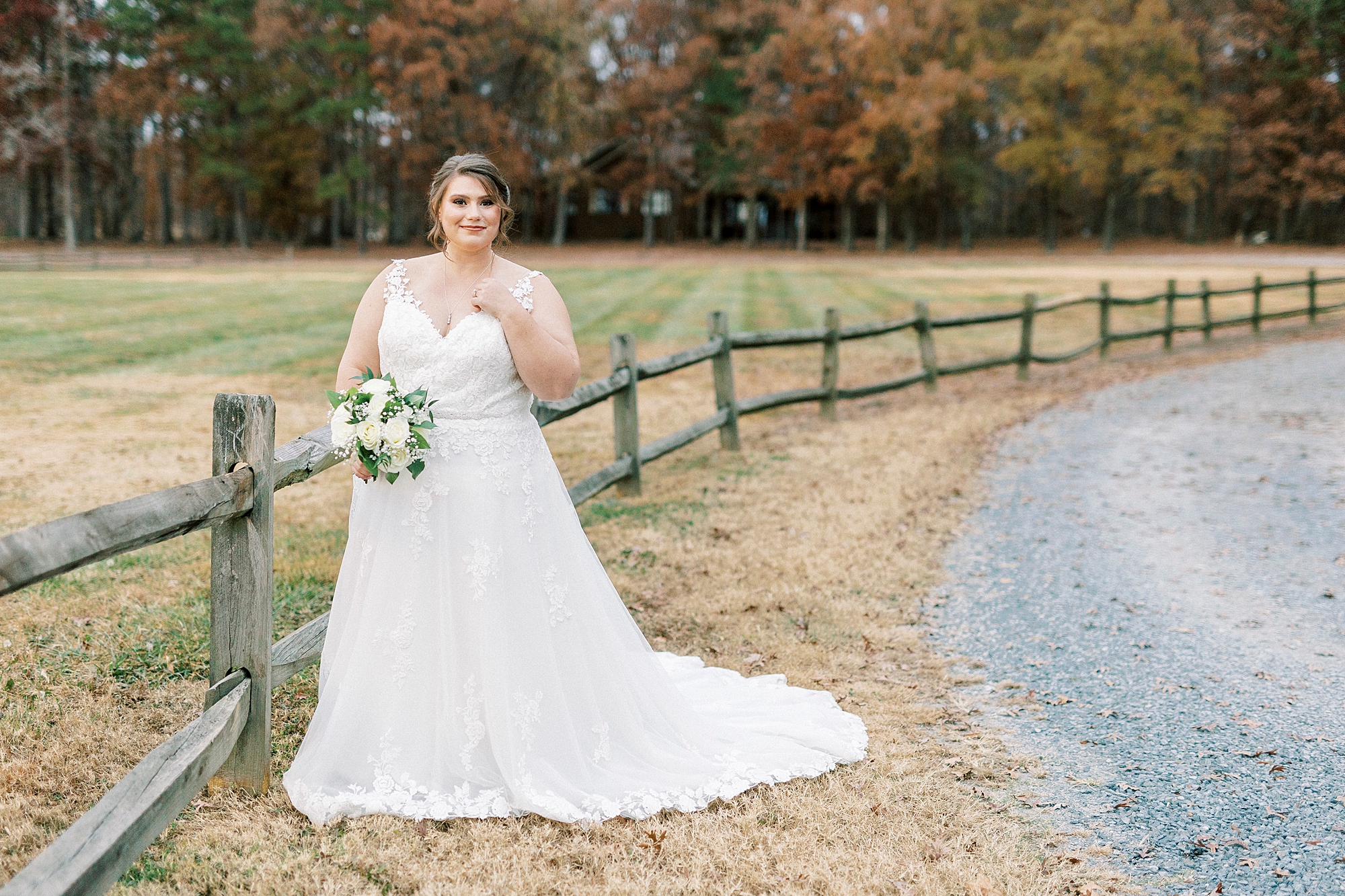 bride smiles with hand near top of wedding gown at the Farm at Brusharbor