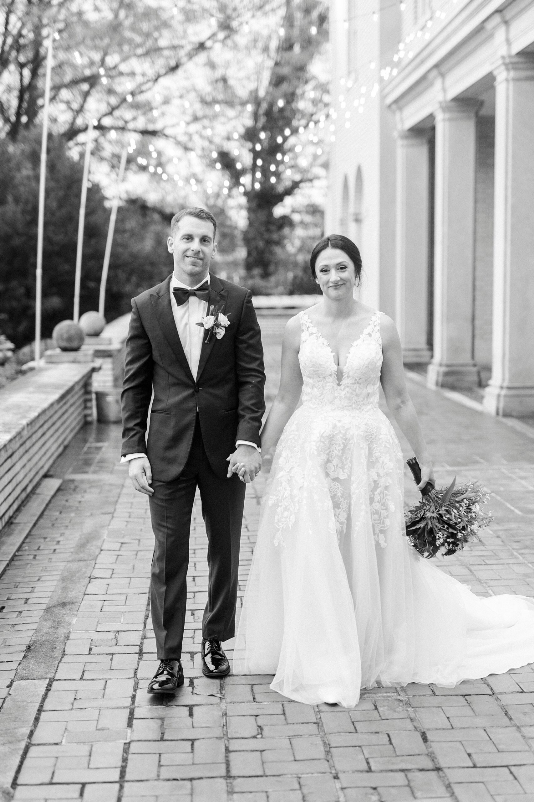 bride and groom hold hands walking on patio of Separk Mansion