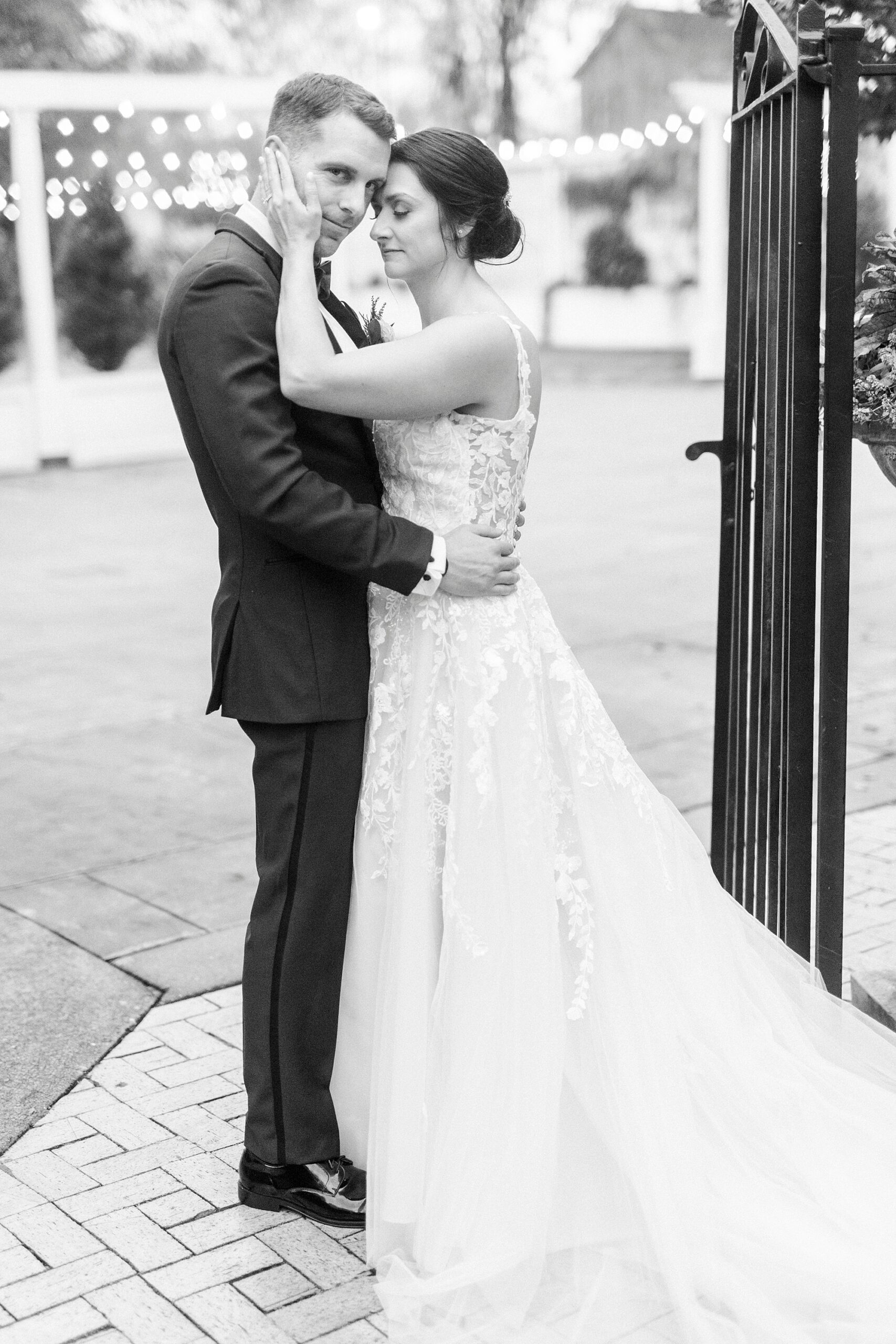 bride hugs groom by wrought iron gate outside Separk Mansion in Charlotte NC