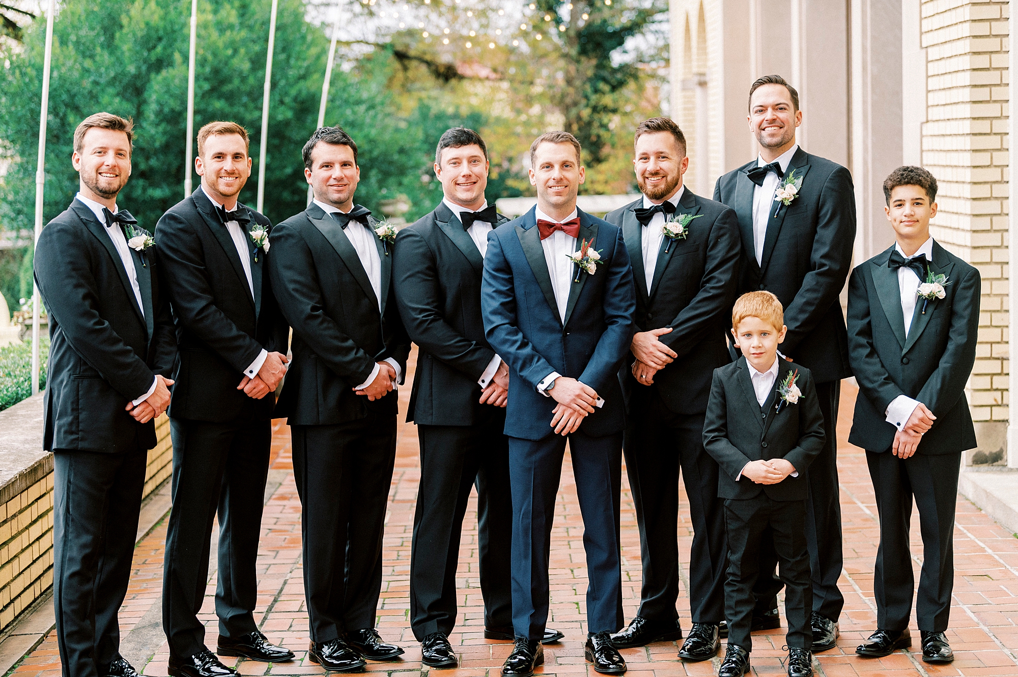 groom in navy suit poses with groomsmen in black suits for classic winter wedding at Separk Mansion