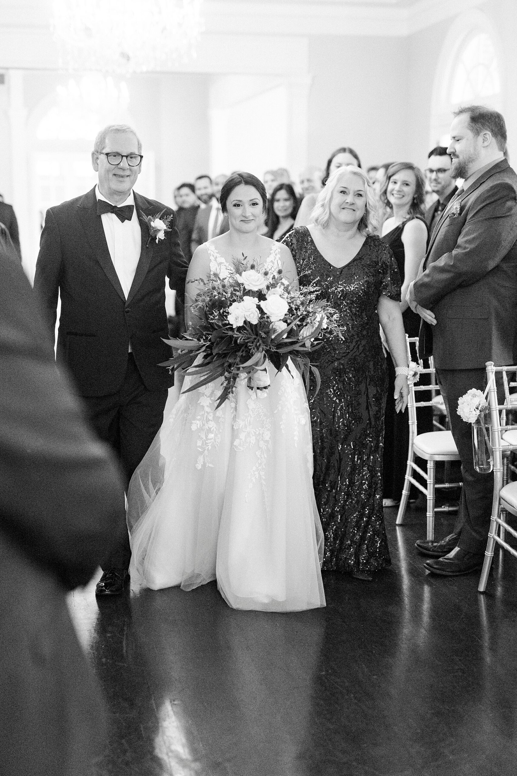 bride walks down aisle with her parents during winter wedding ceremony at Separk Mansion