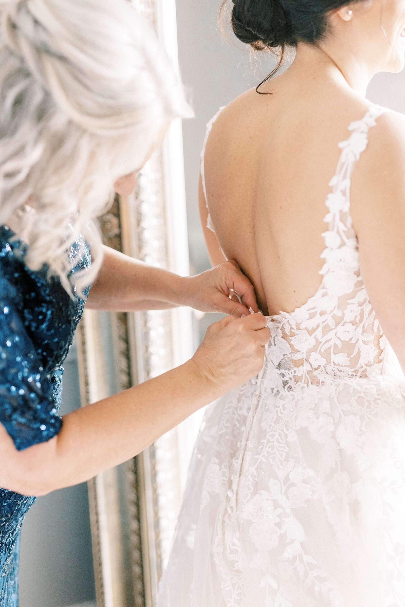 mother helps button up wedding gown for bride in Separk Mansion bridal suite