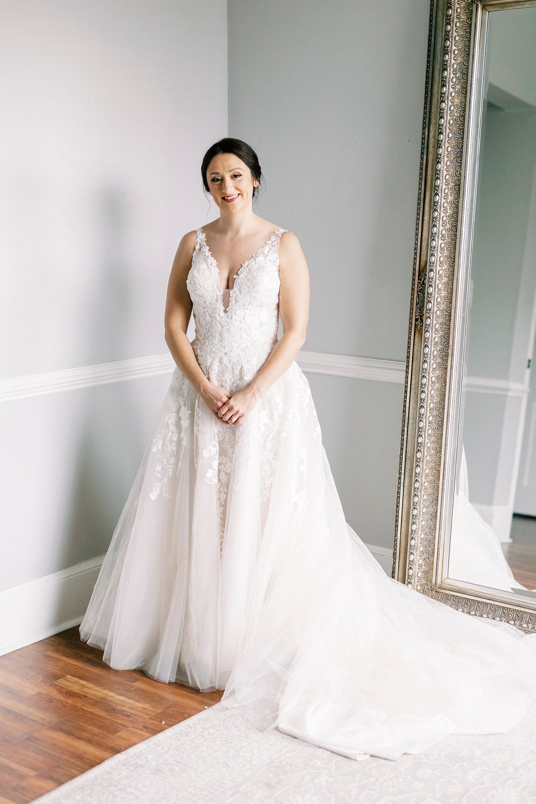 bride smiles standing in elegant wedding dress 