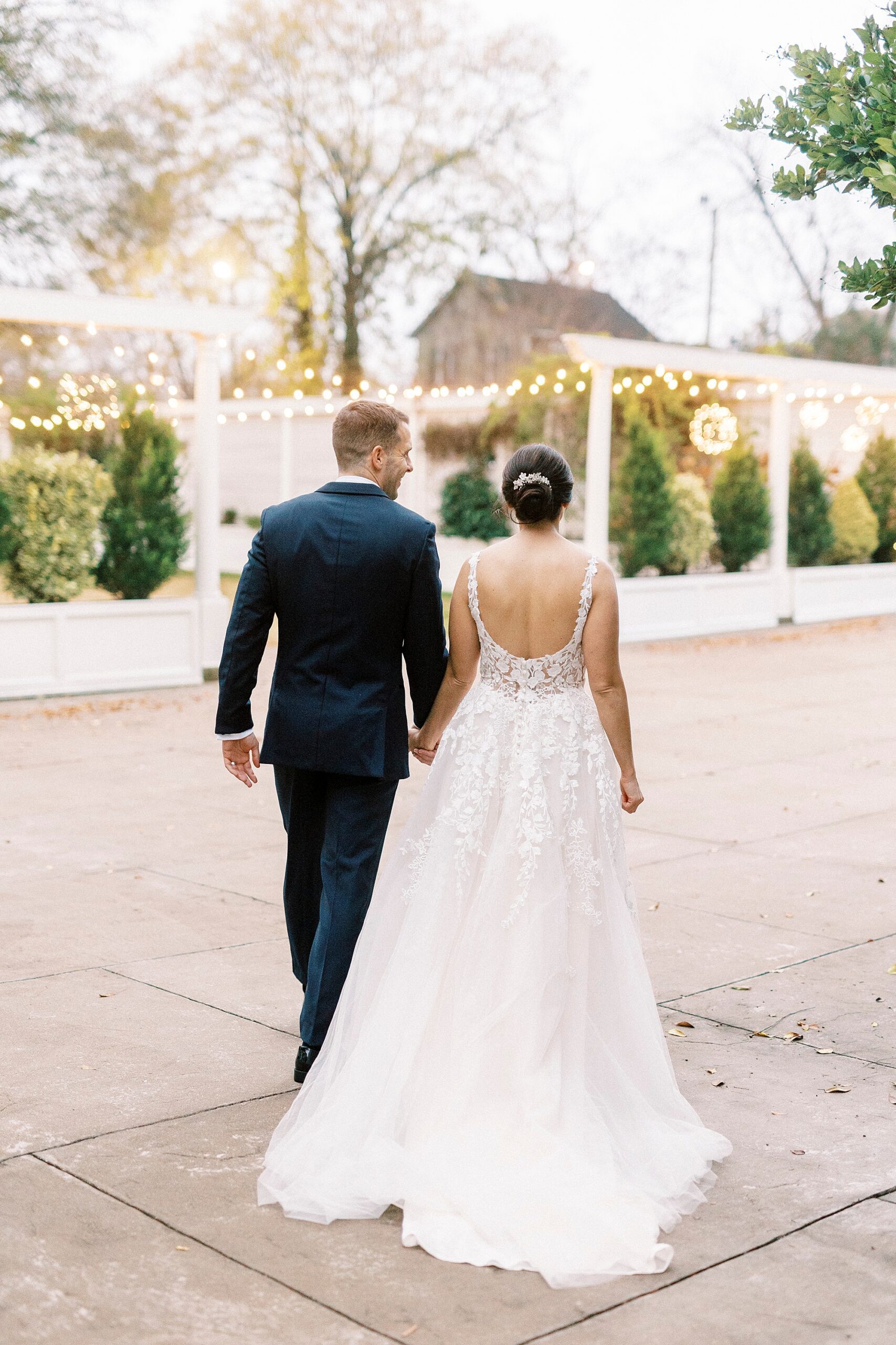 bride and groom hold hands walking across brick patio at Separk Mansion