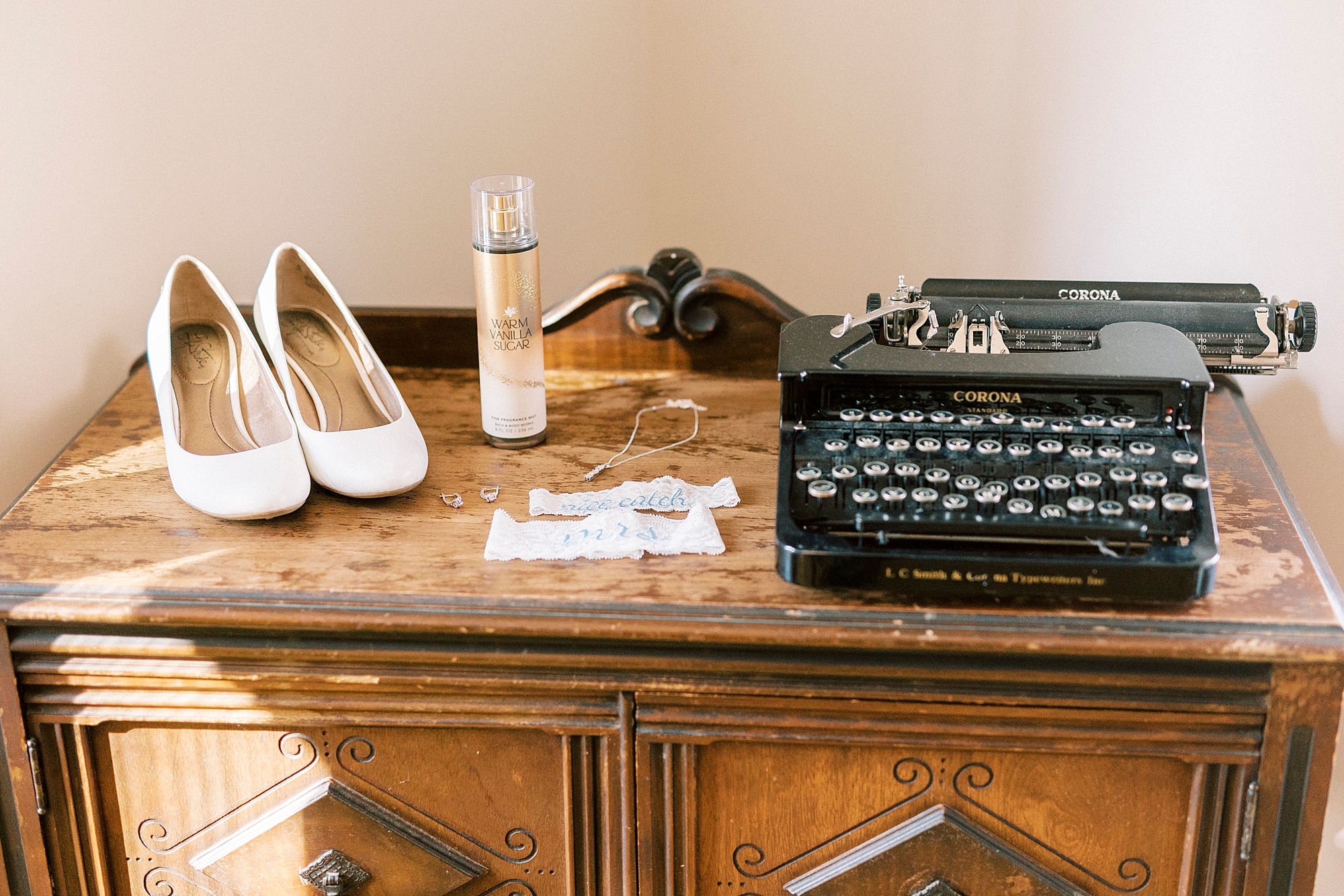 bride's shoes and perfume sit next to typewriter at the Farm at Brusharbor
