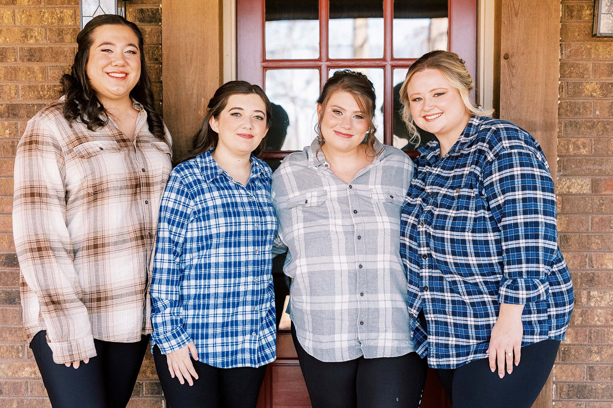 bride poses with bridesmaids in flannel shirts outside the Farm at Brusharbor