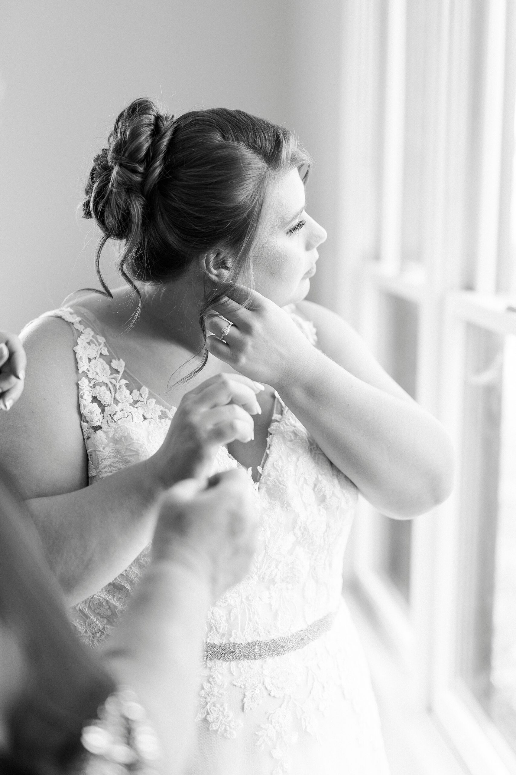 bride puts earring on during prep inside the suite at the Farm at Brusharbor