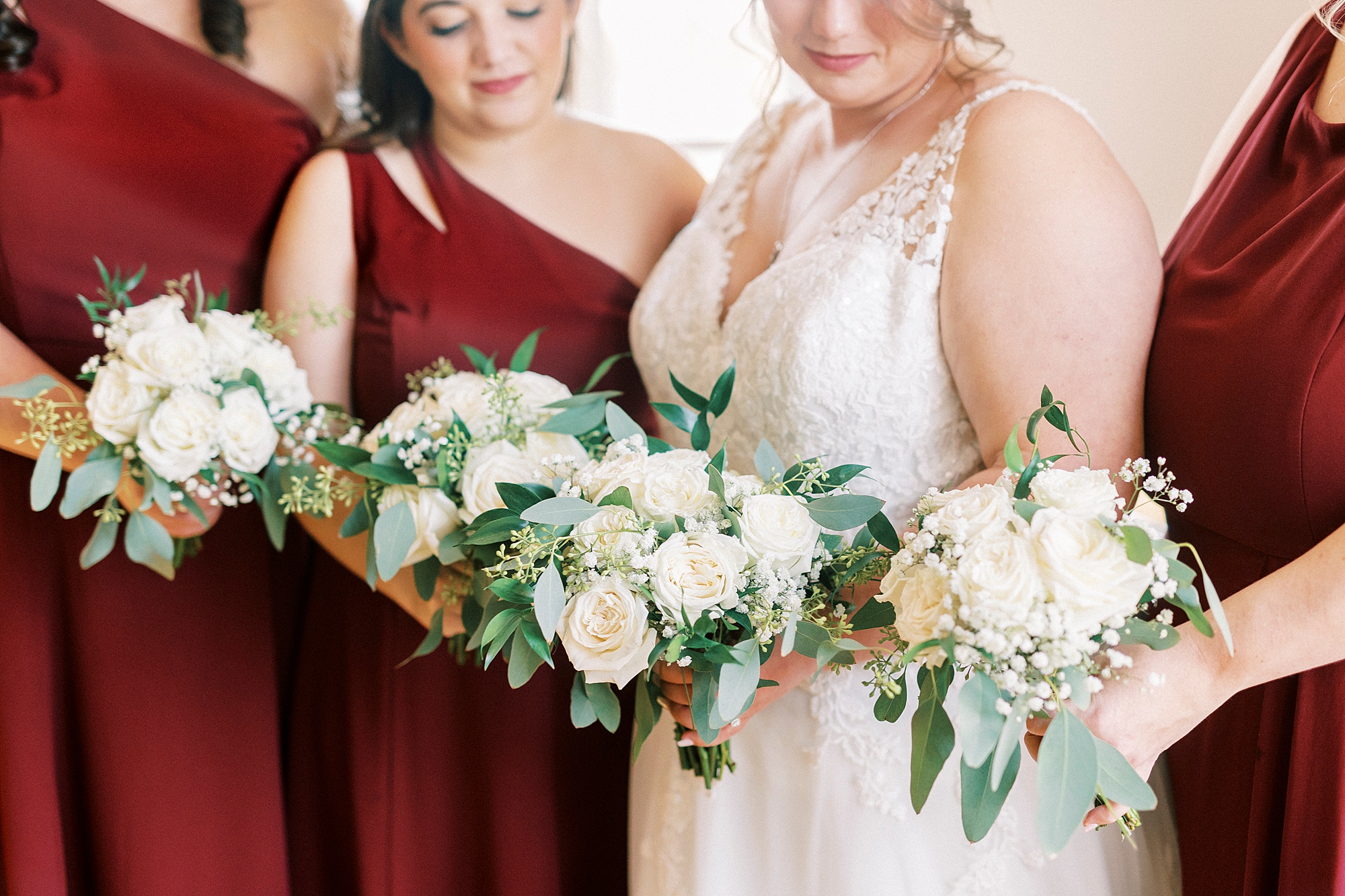 bride and bridesmaids hold bouquets of white flowers for fall wedding day at the Farm at Brusharbor
