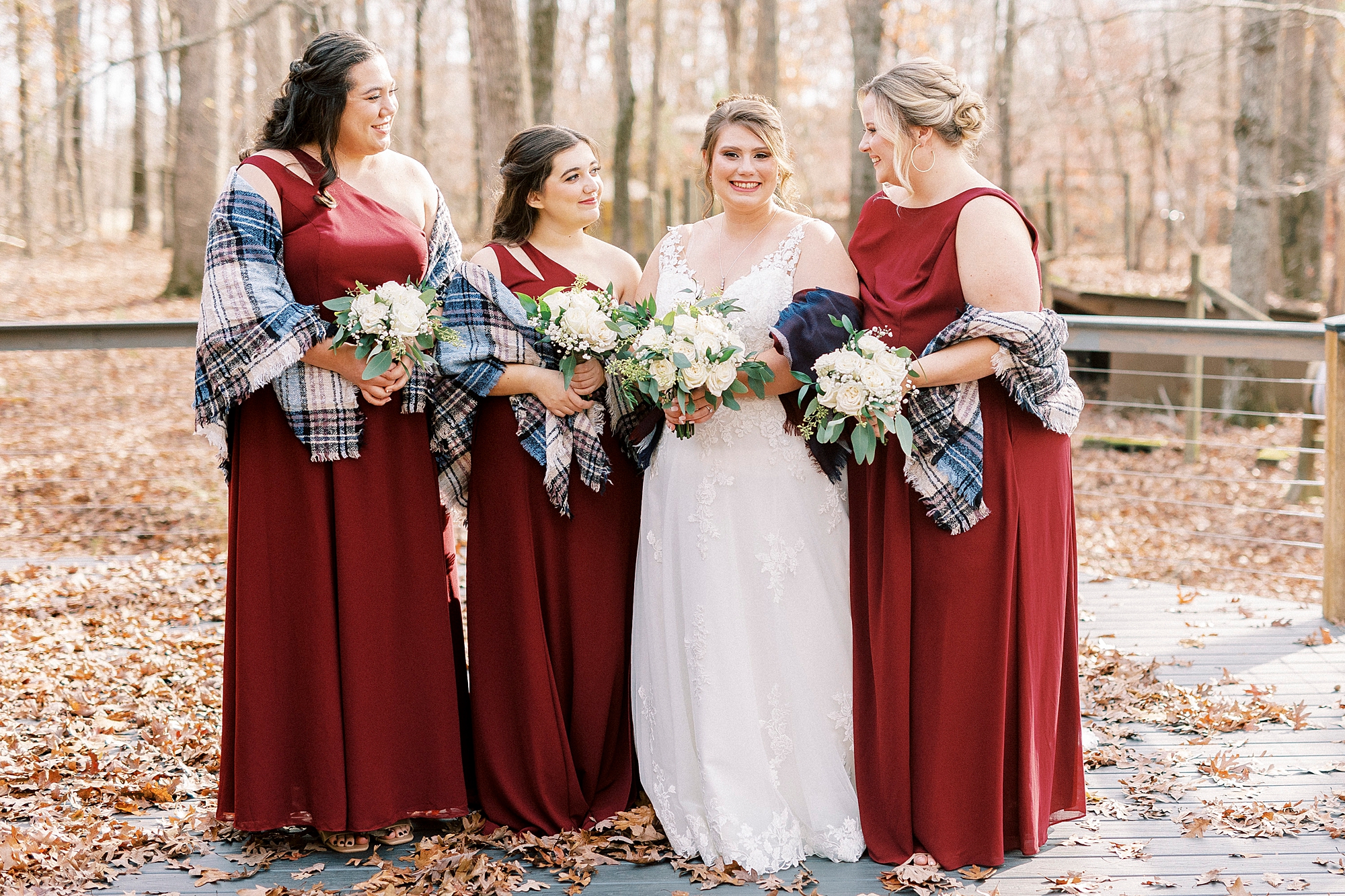 bride and bridesmaids pose in plaid shawls for fall wedding