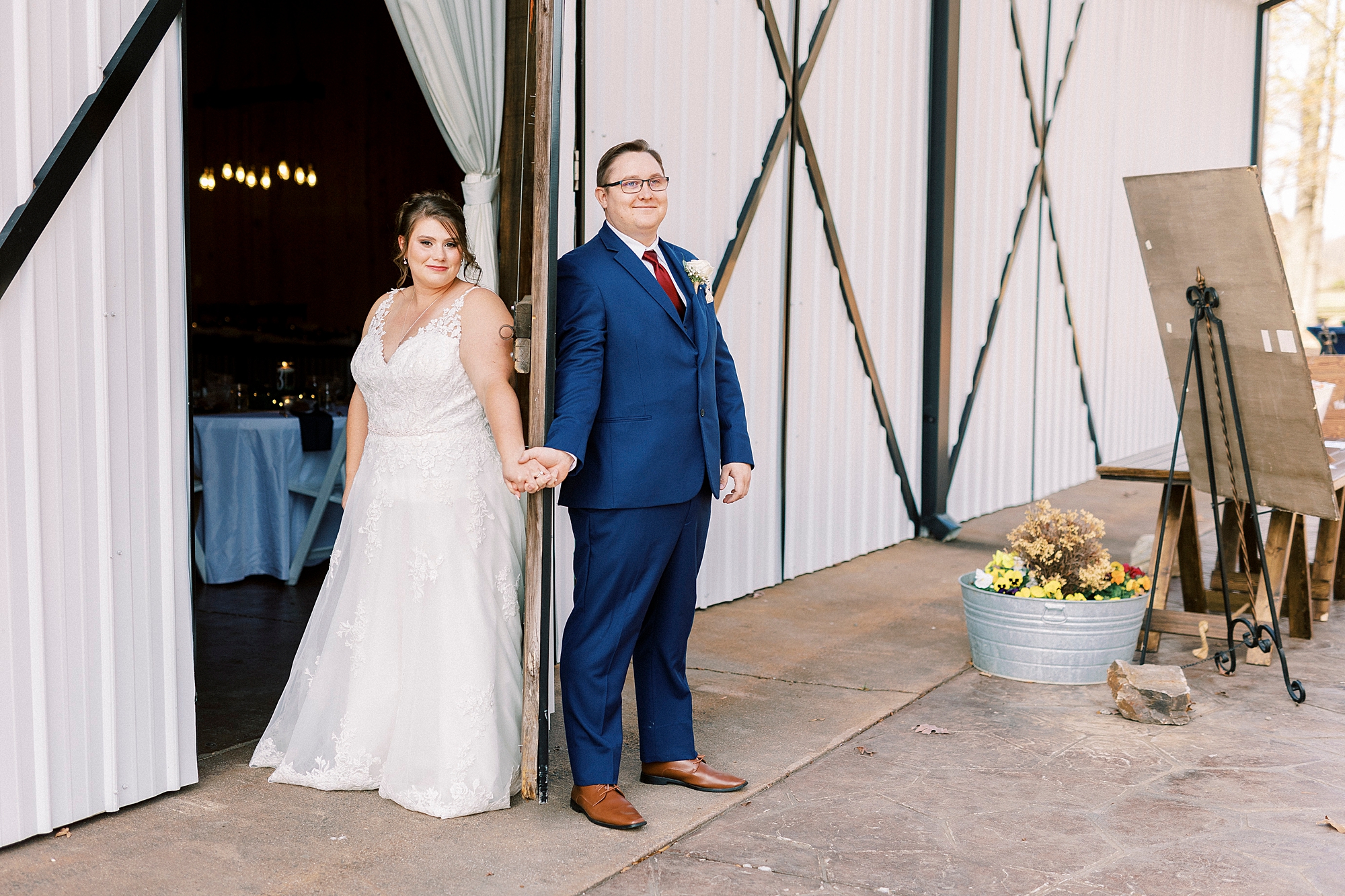 bride and groom hold hands around barn door at the Farm at Brusharbor