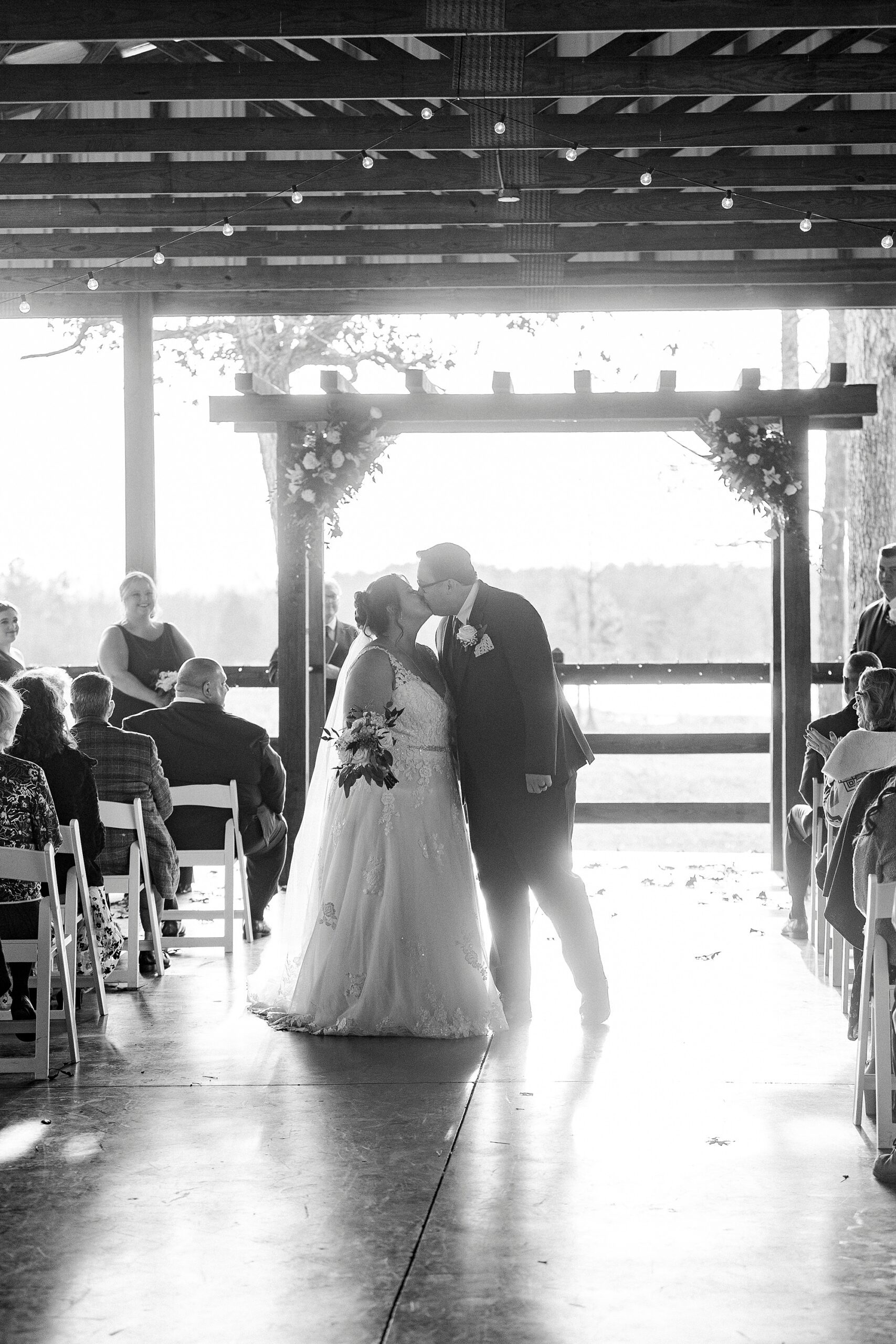 bride and groom kiss after walking up aisle after wedding ceremony at the Farm at Brusharbor pavilion 