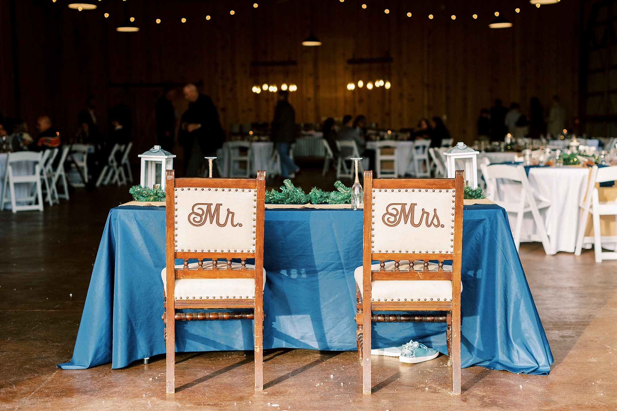 brown and white chairs sit at head table for reception in barn at the Farm at Brusharbor