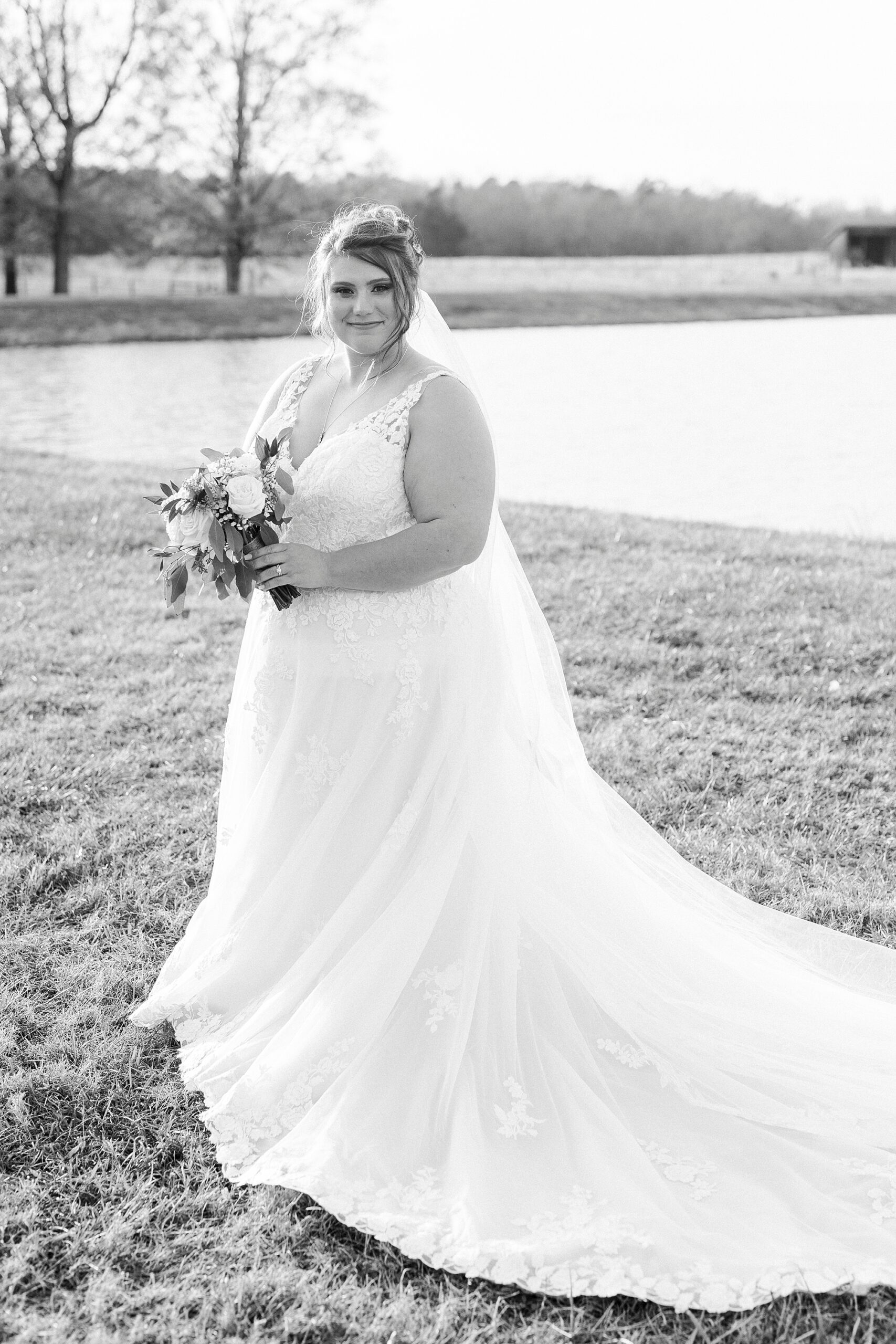 bride poses on lawn with wedding dress skirt around her at the Farm at Brusharbor