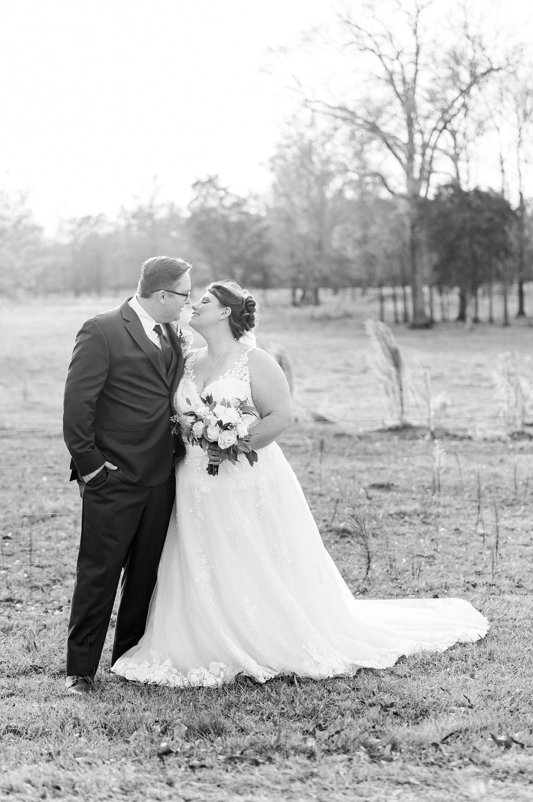 bride hugs groom leaning up to kiss him during portraits at the Farm at Brusharbor