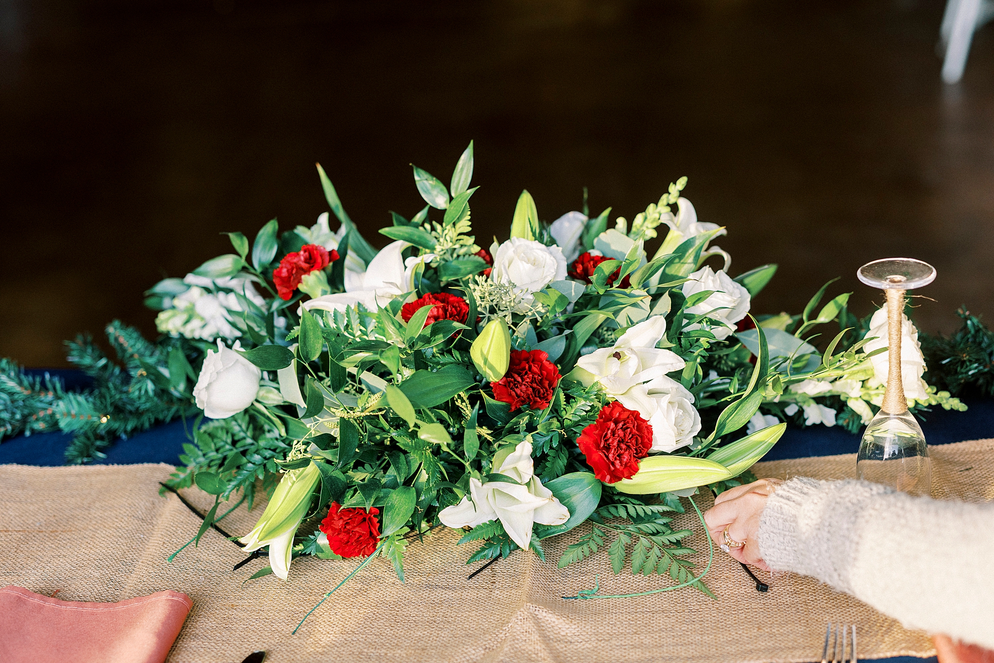 red and white floral arrangement on wooden table for reception at the Farm at Brusharbor