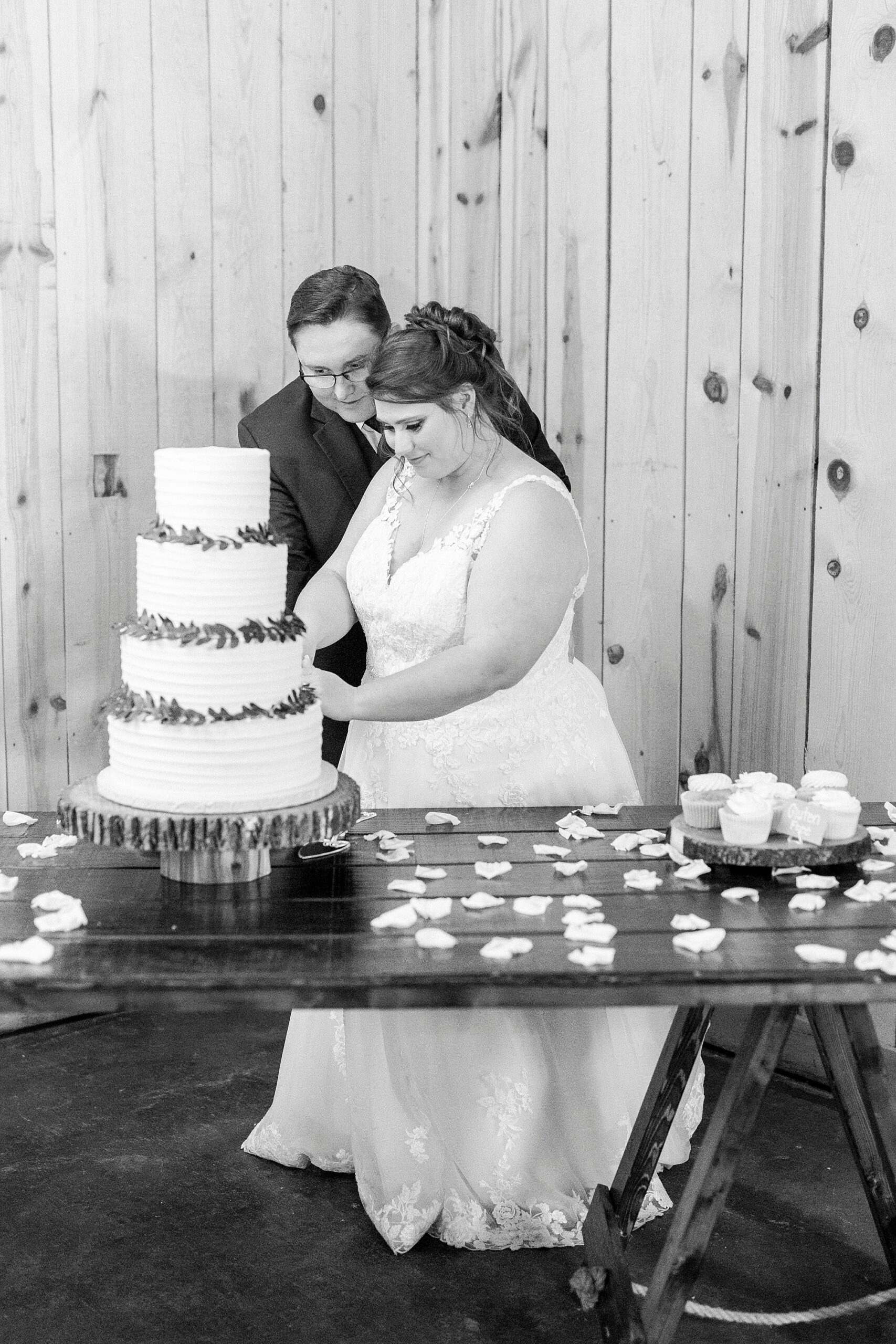 bride and groom cut wedding cake inside the Farm at Brusharbor barn
