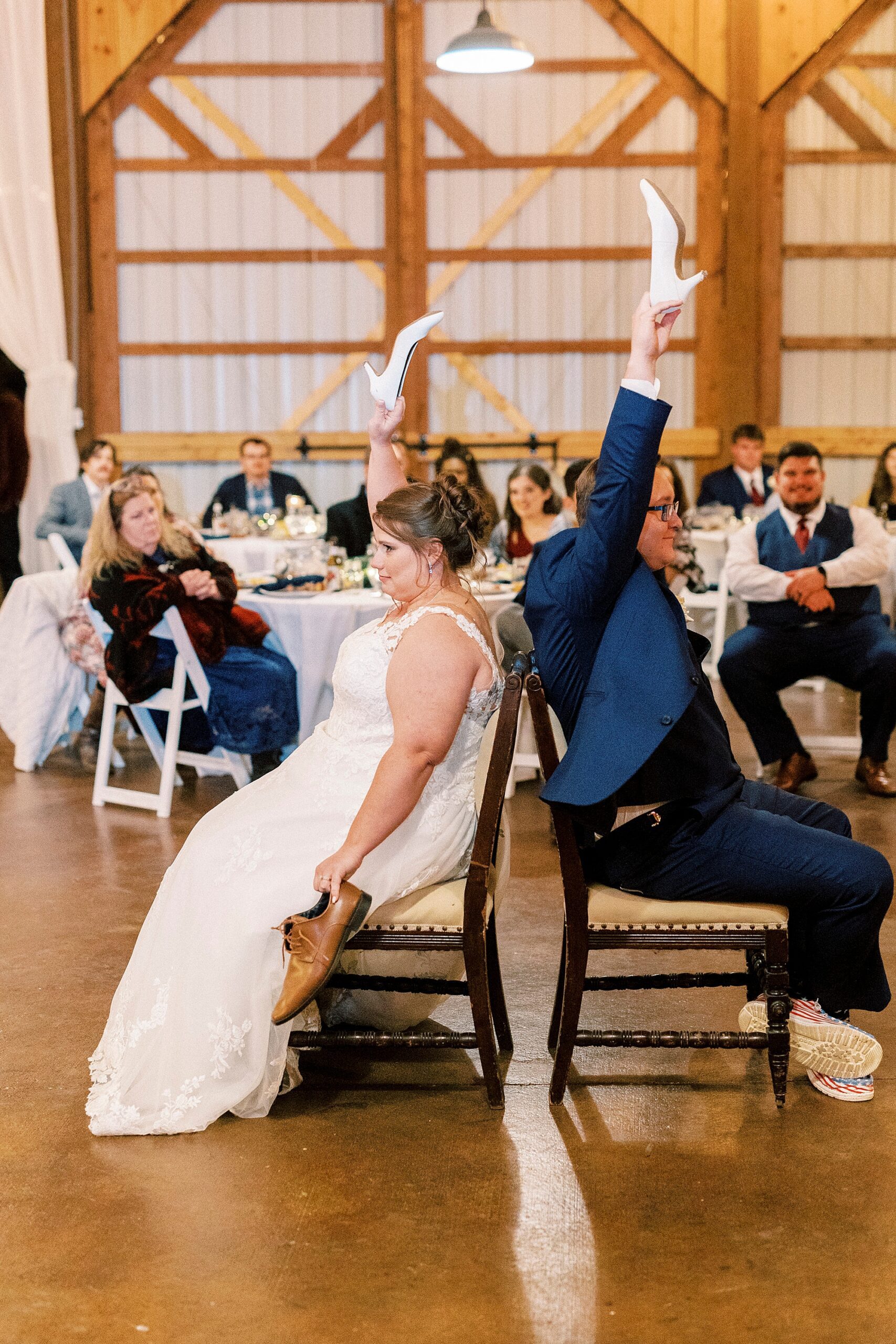 bride and groom play the shoe game during barn wedding reception at the Farm at Brusharbor