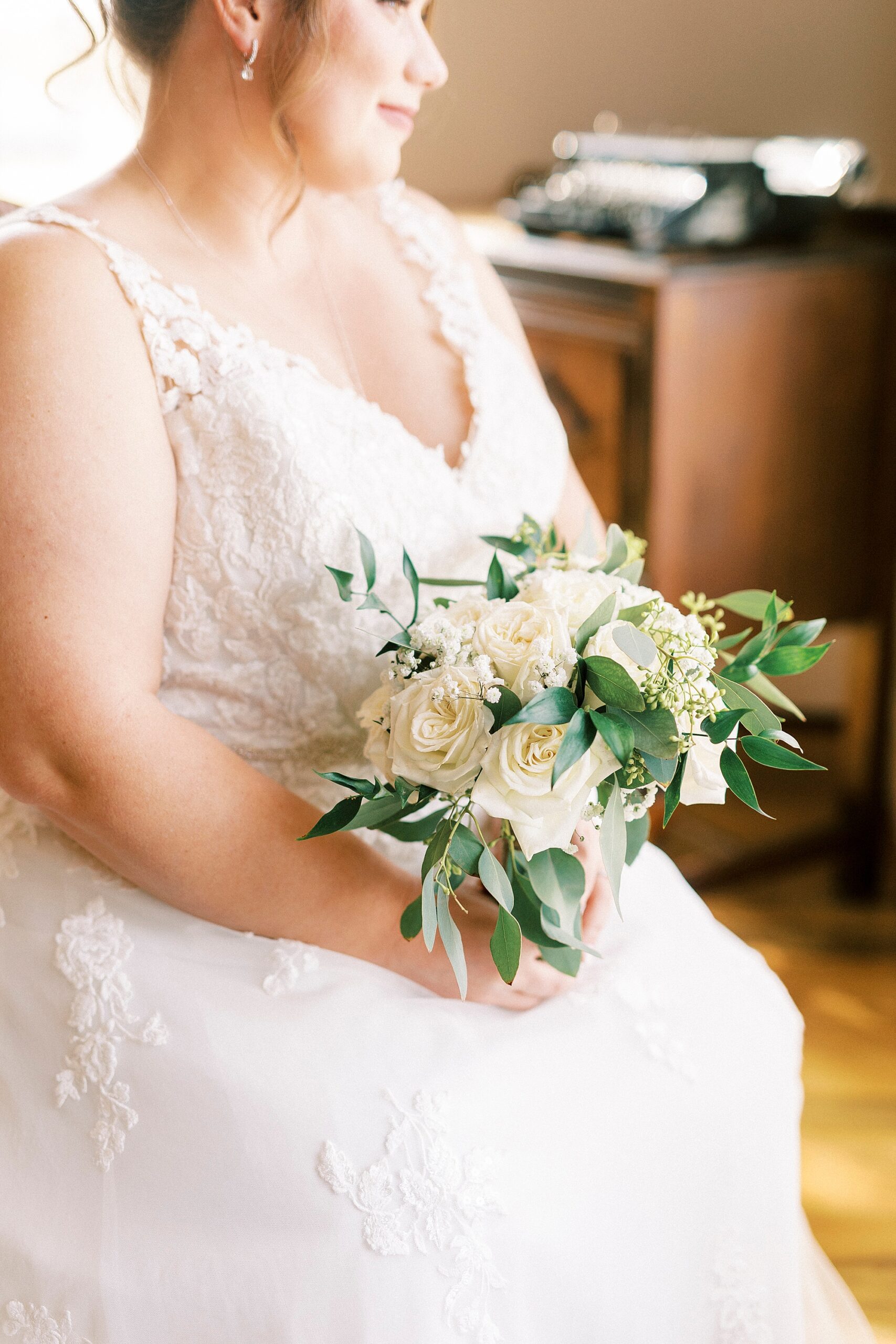 bride's bouquet of white flowers and greenery for fall wedding