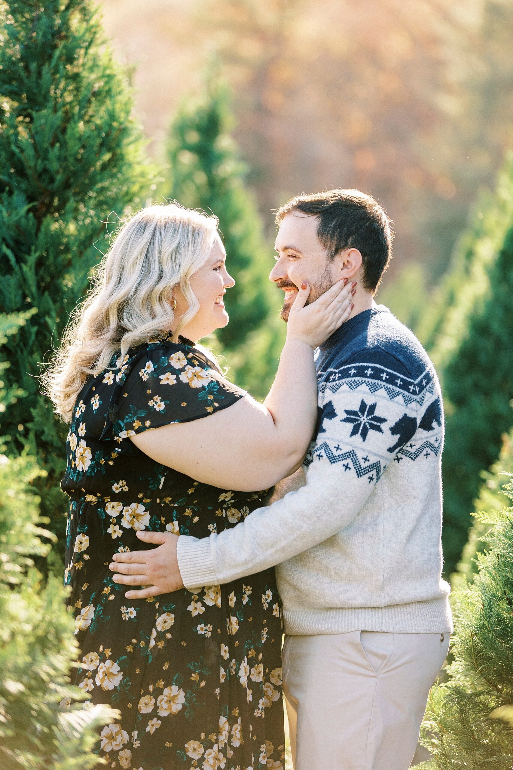 blonde woman reaches up to touch man's face during holiday mini sessions