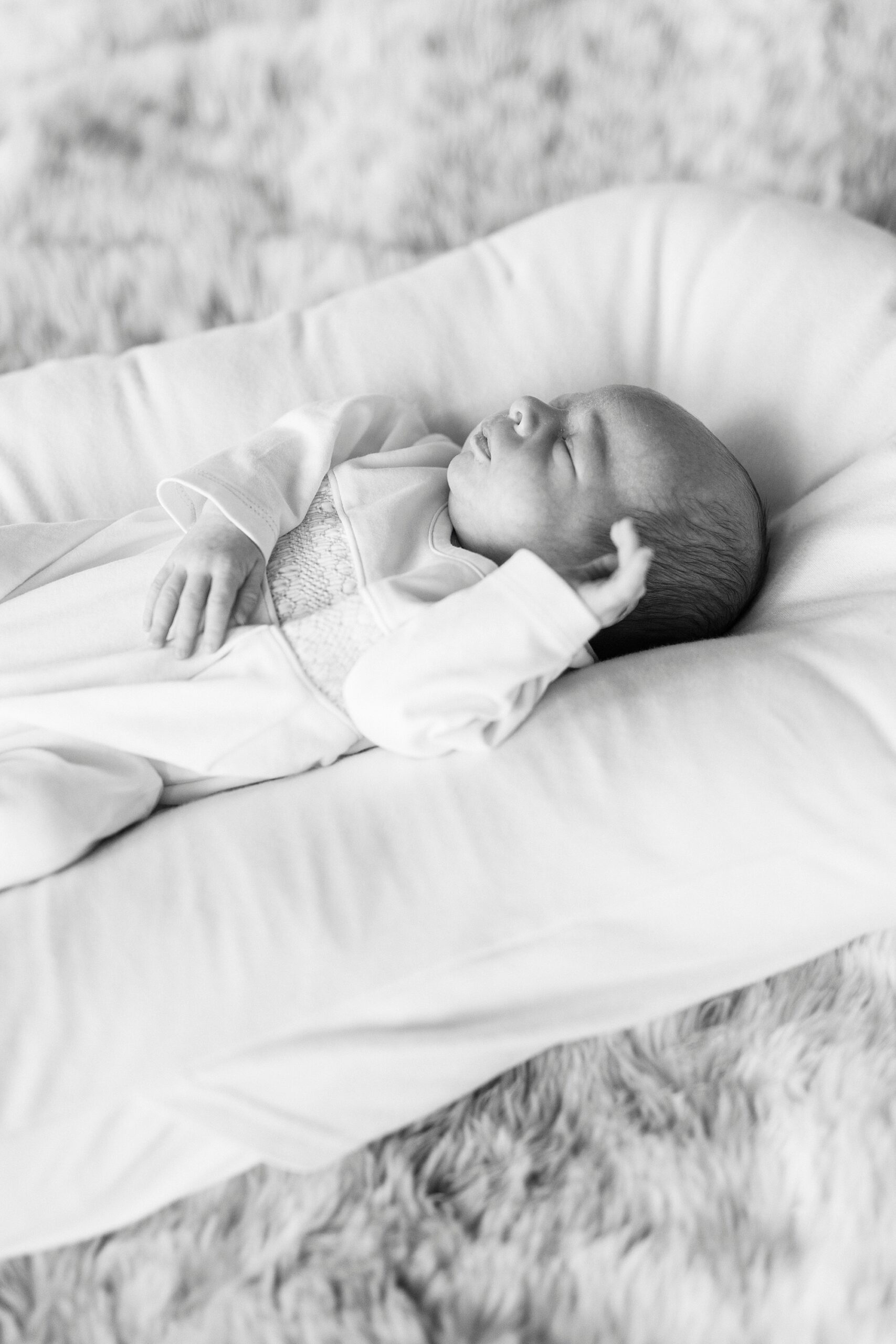 baby boy lays on pillow inside studio during Christmas portraits 