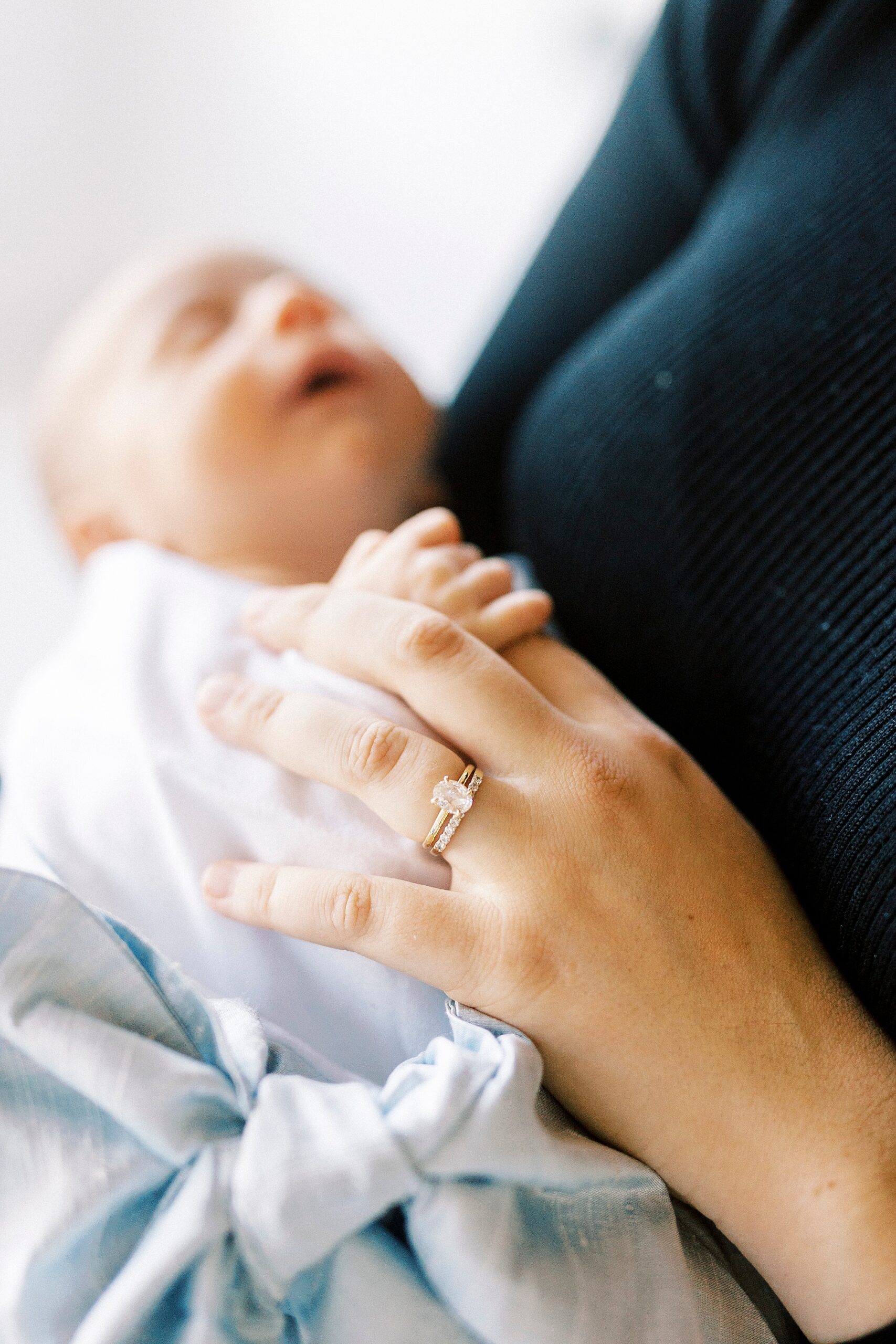 mom holds newborn son's hands