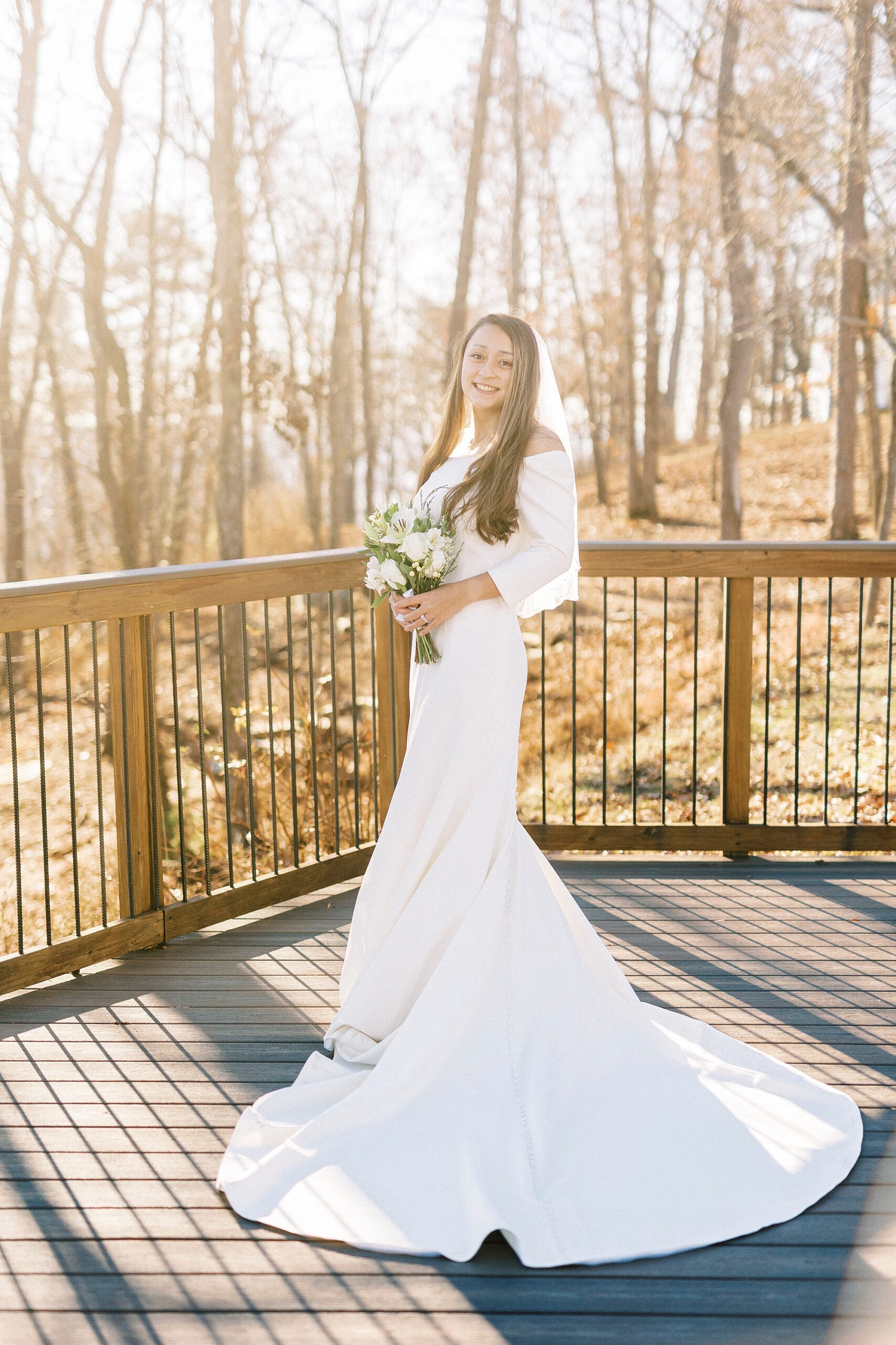 bride stands twisting in wedding gown on wooden platform at Morrow Mountain