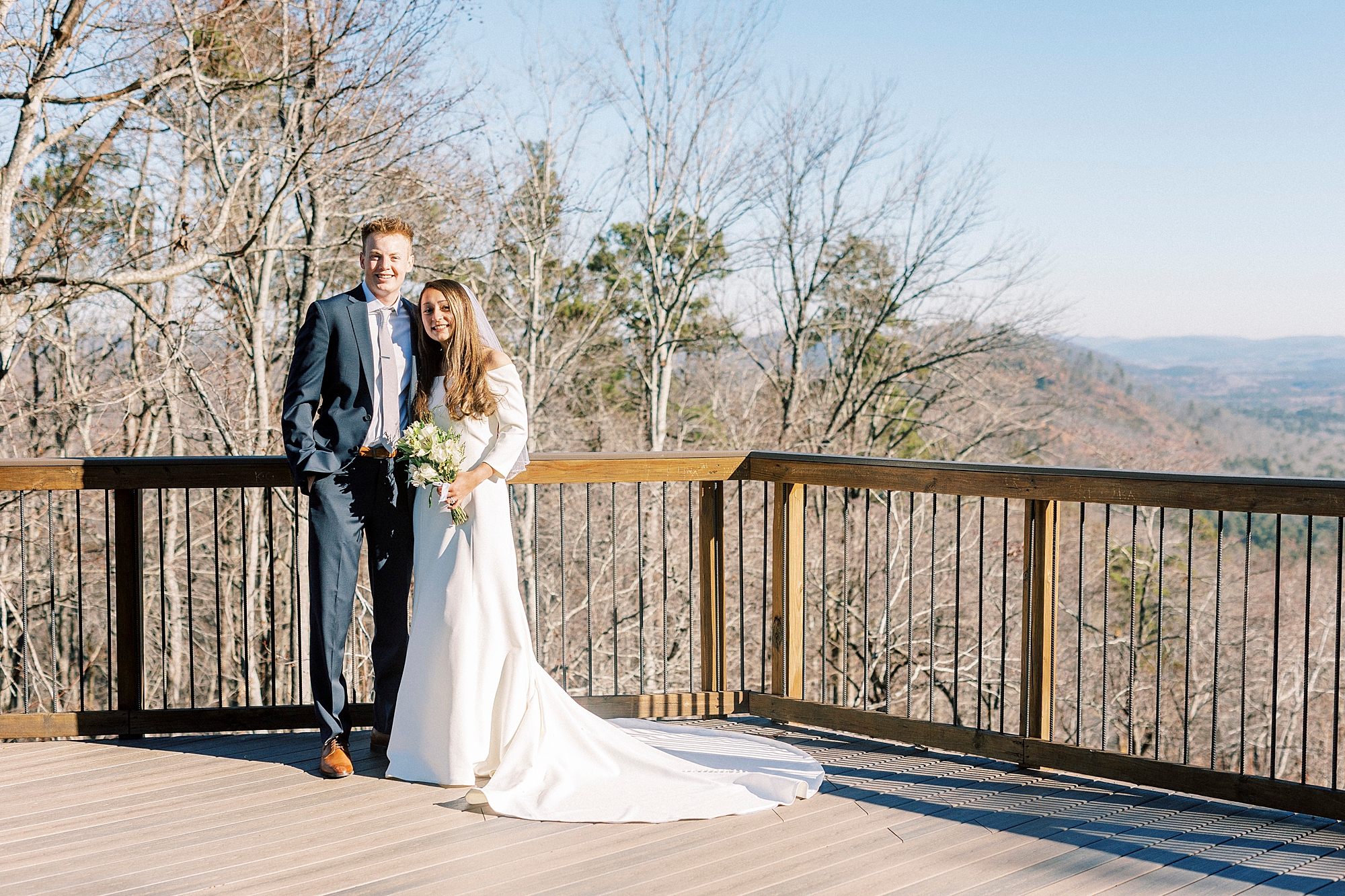 bride leans into groom on wooden patio at Morrow Mountain