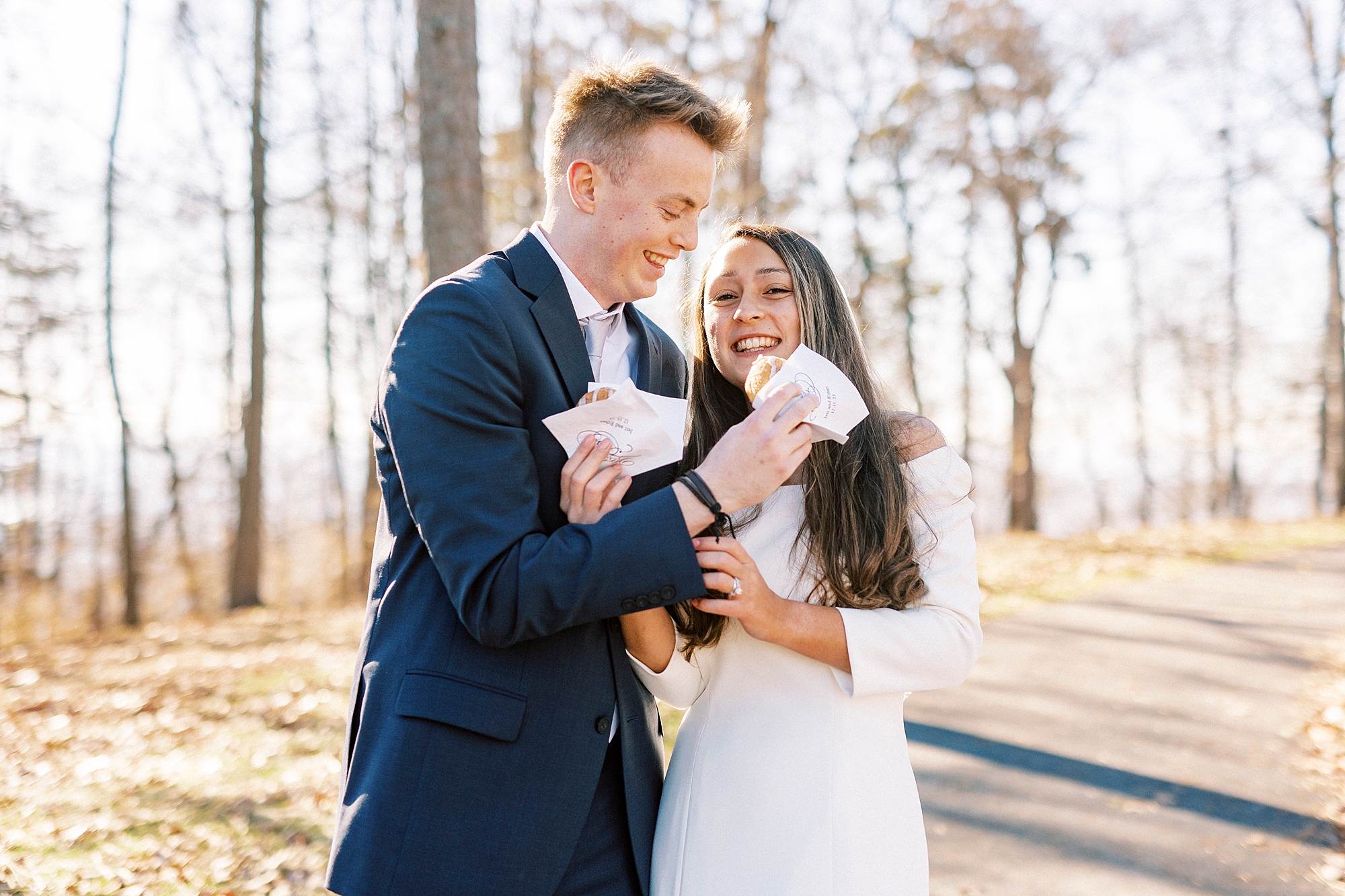 bride and groom twist arms to feed donuts to each other 