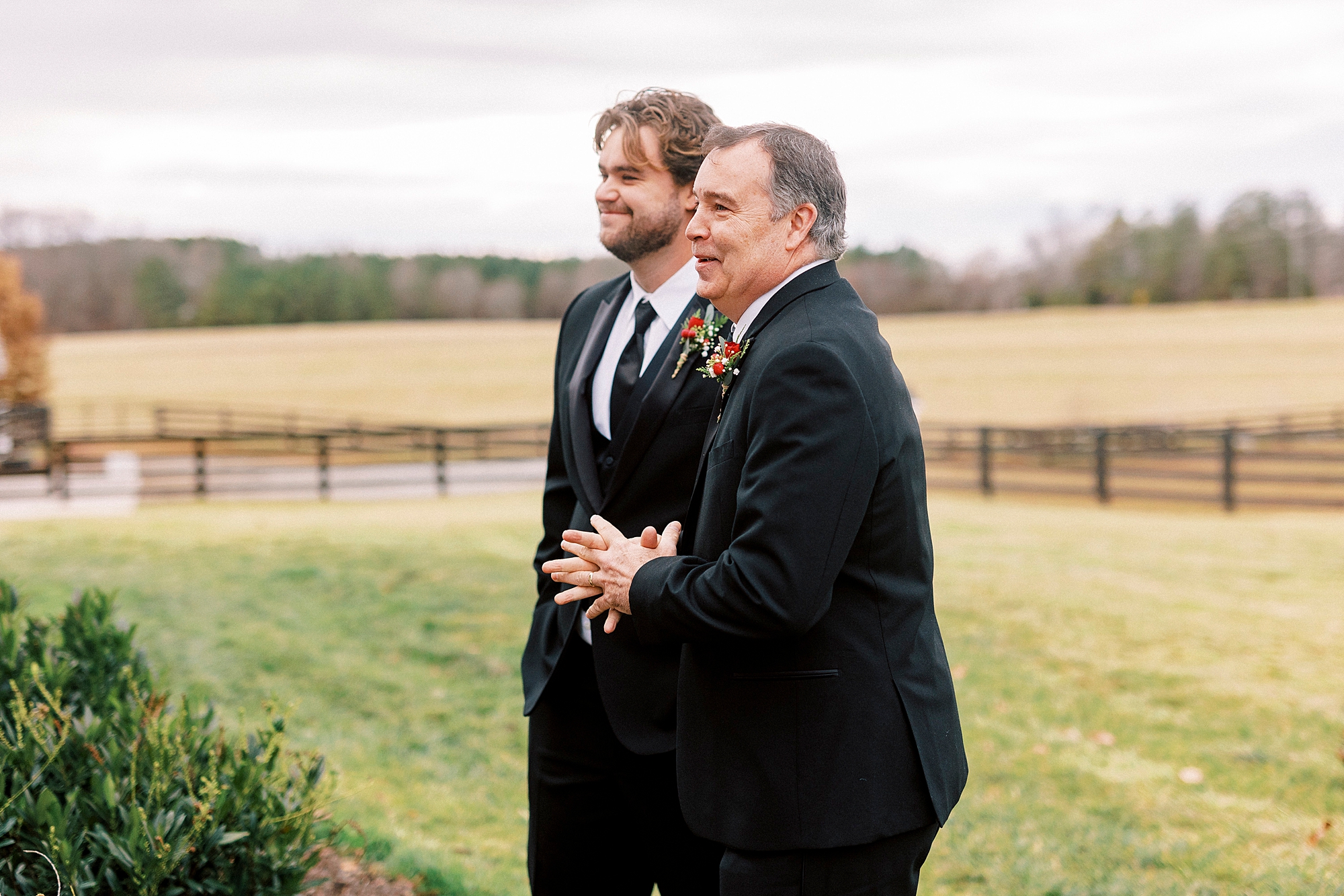 father and groomsman talk before wedding at farm