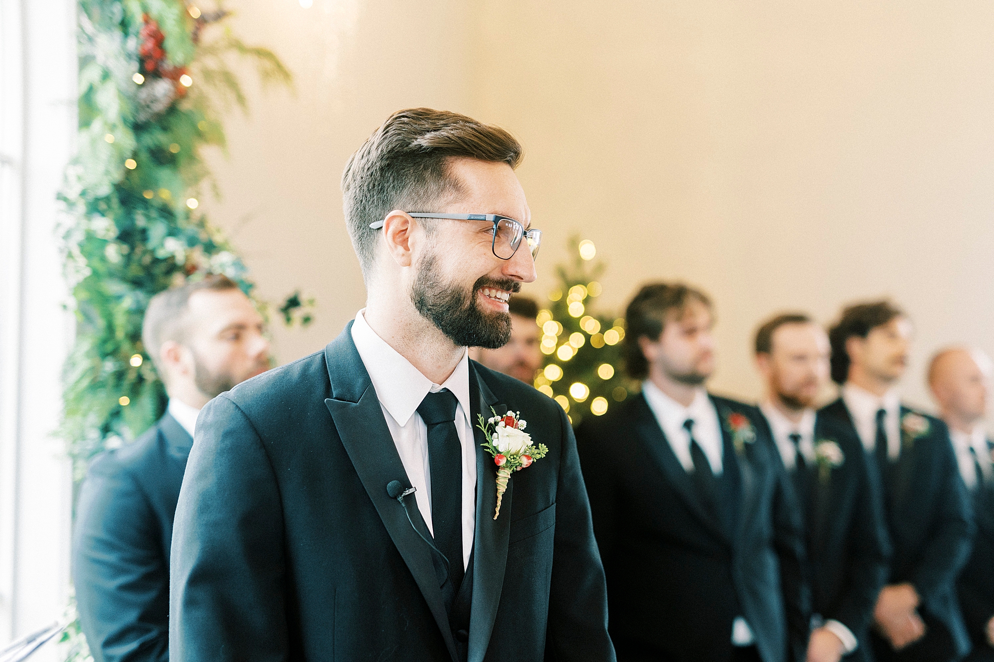 groom grins watching bride walk down aisle for winter Chickadee Hill Farms wedding ceremony