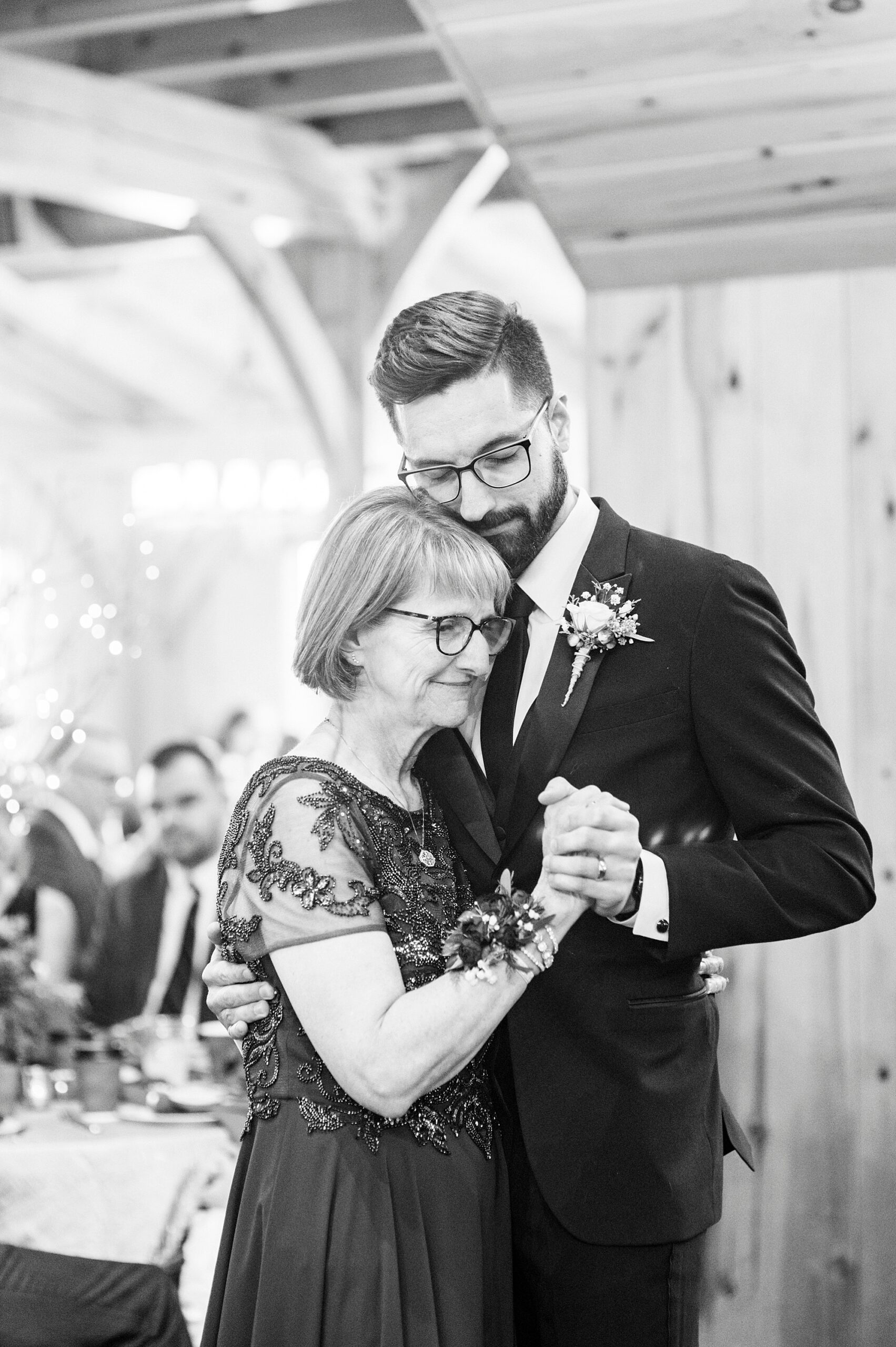 groom hugs mother to him during reception at Chickadee Hill Farms