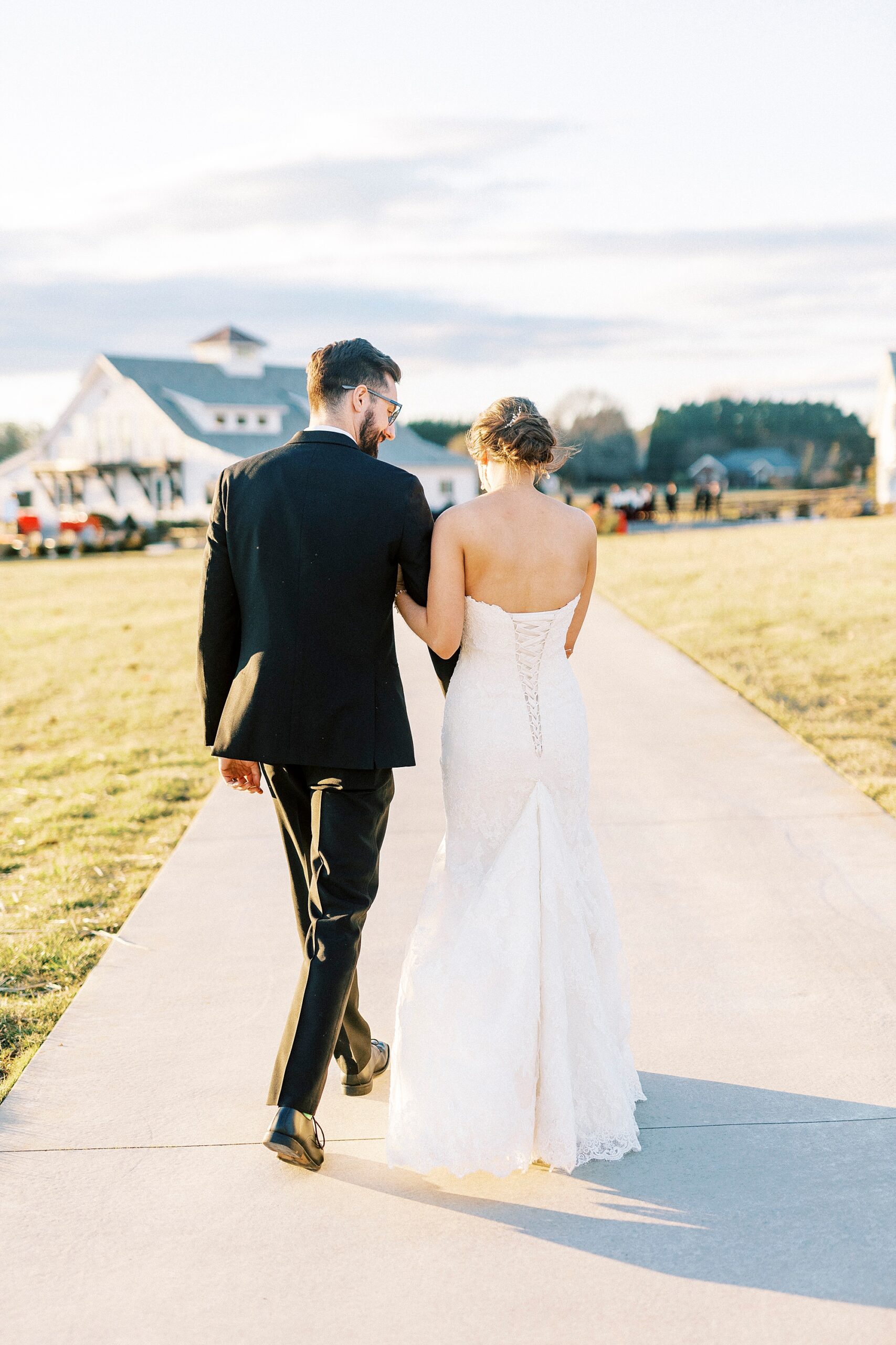 newlyweds hold hands walking and talking outside Chickadee Hill Farms