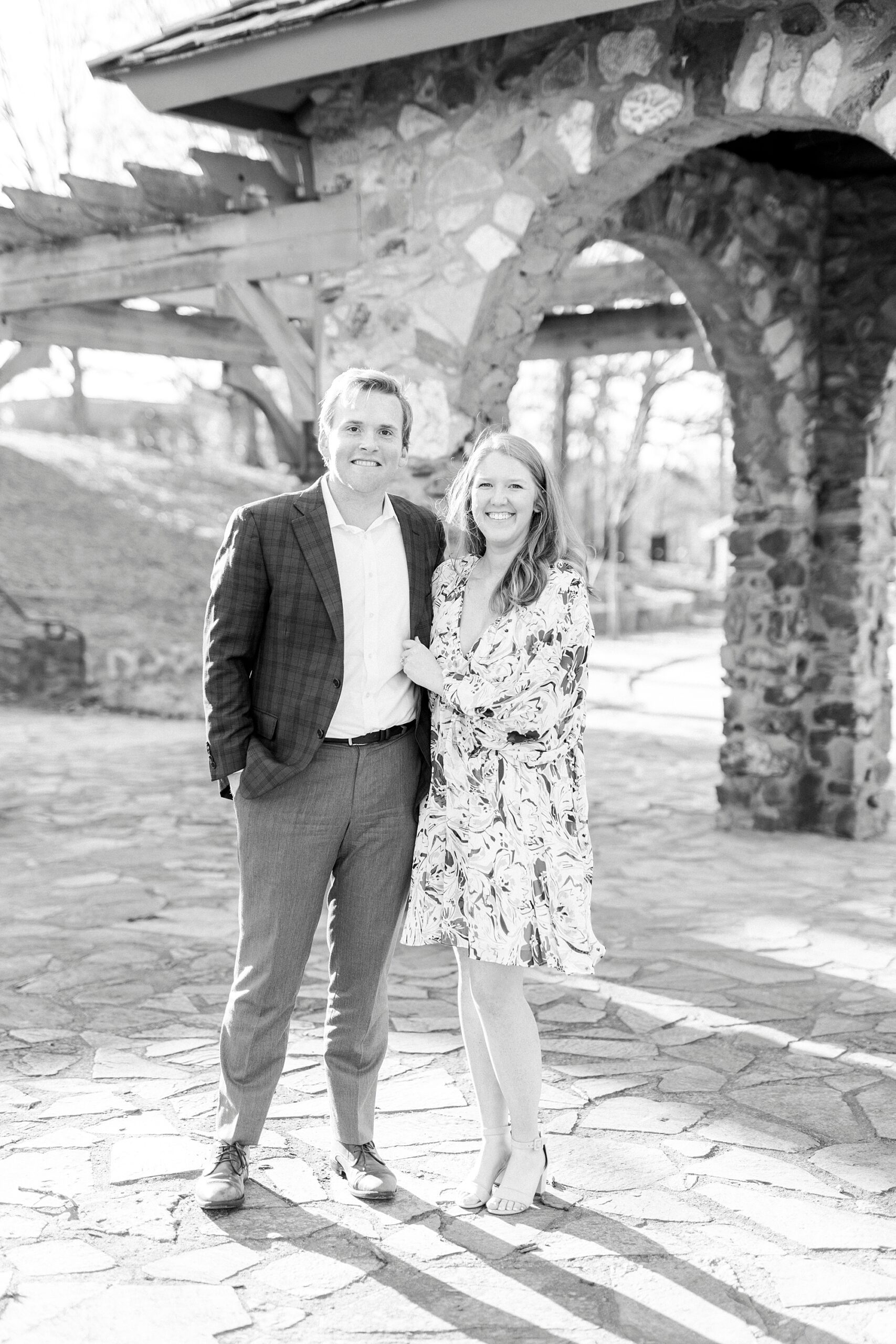 engaged couple hugs by stone archway inside Independence Park