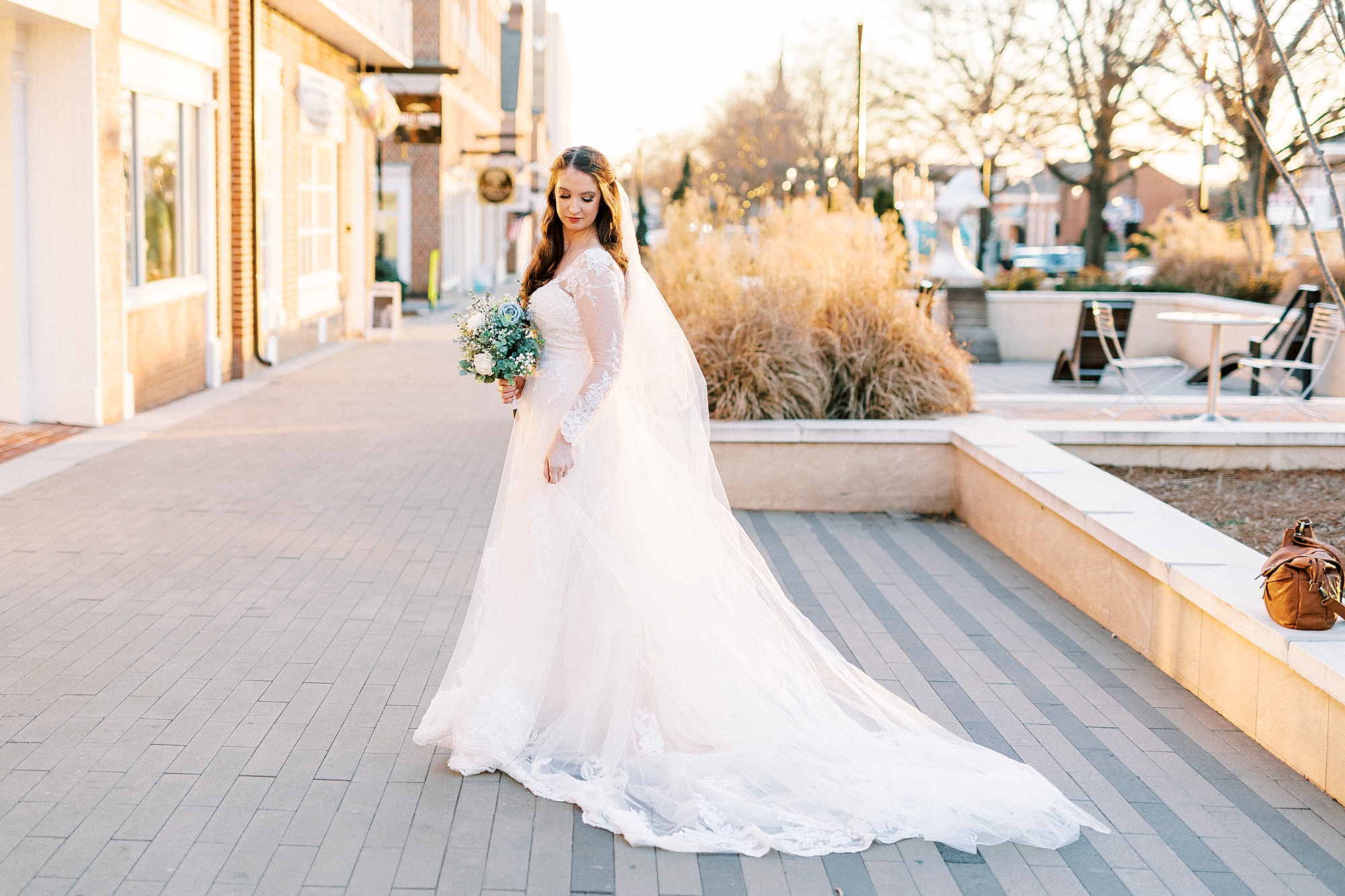 bride smiles on steps in Downtown Kannapolis