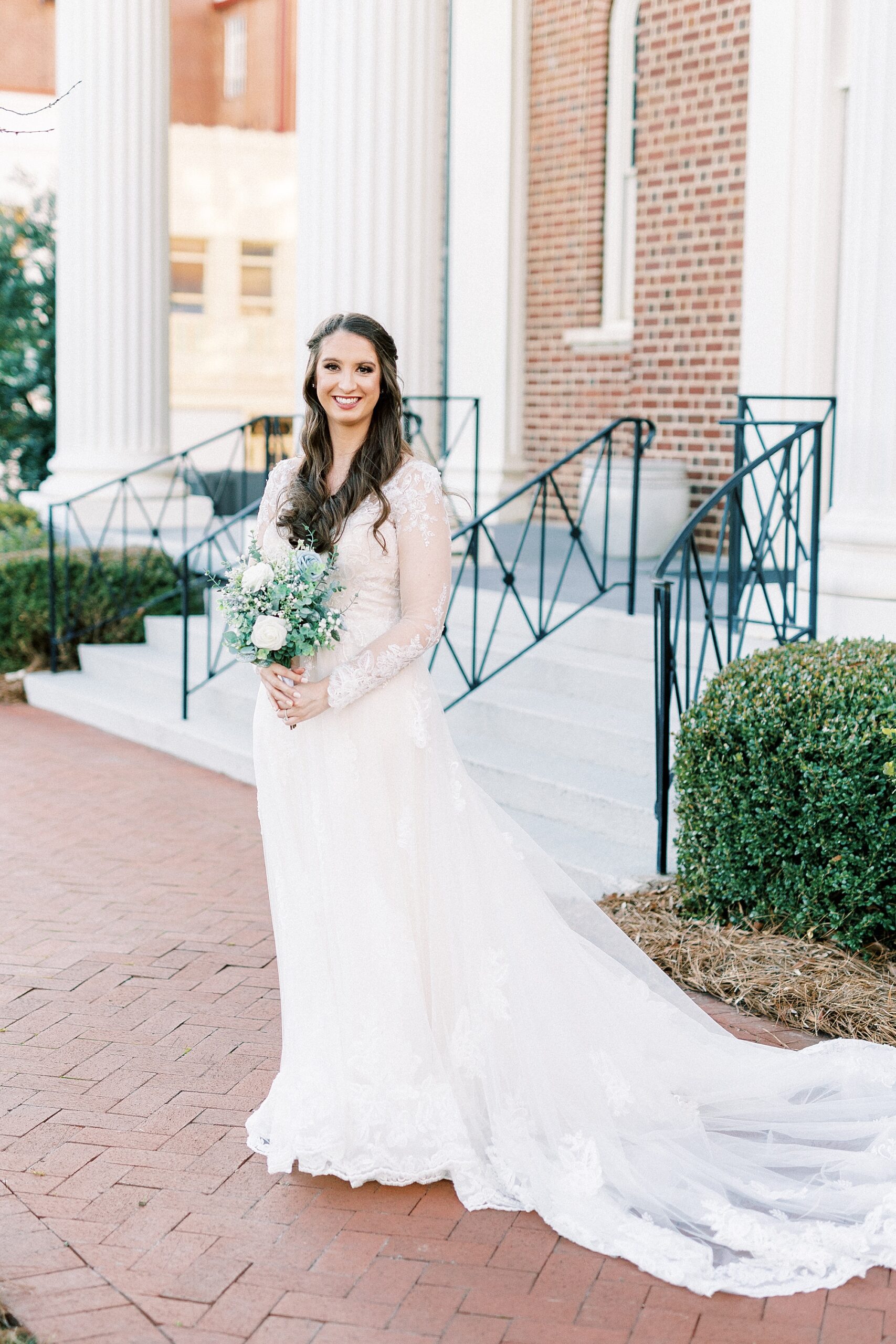 bride stands outside church during bridal portraits Downtown Kannapolis