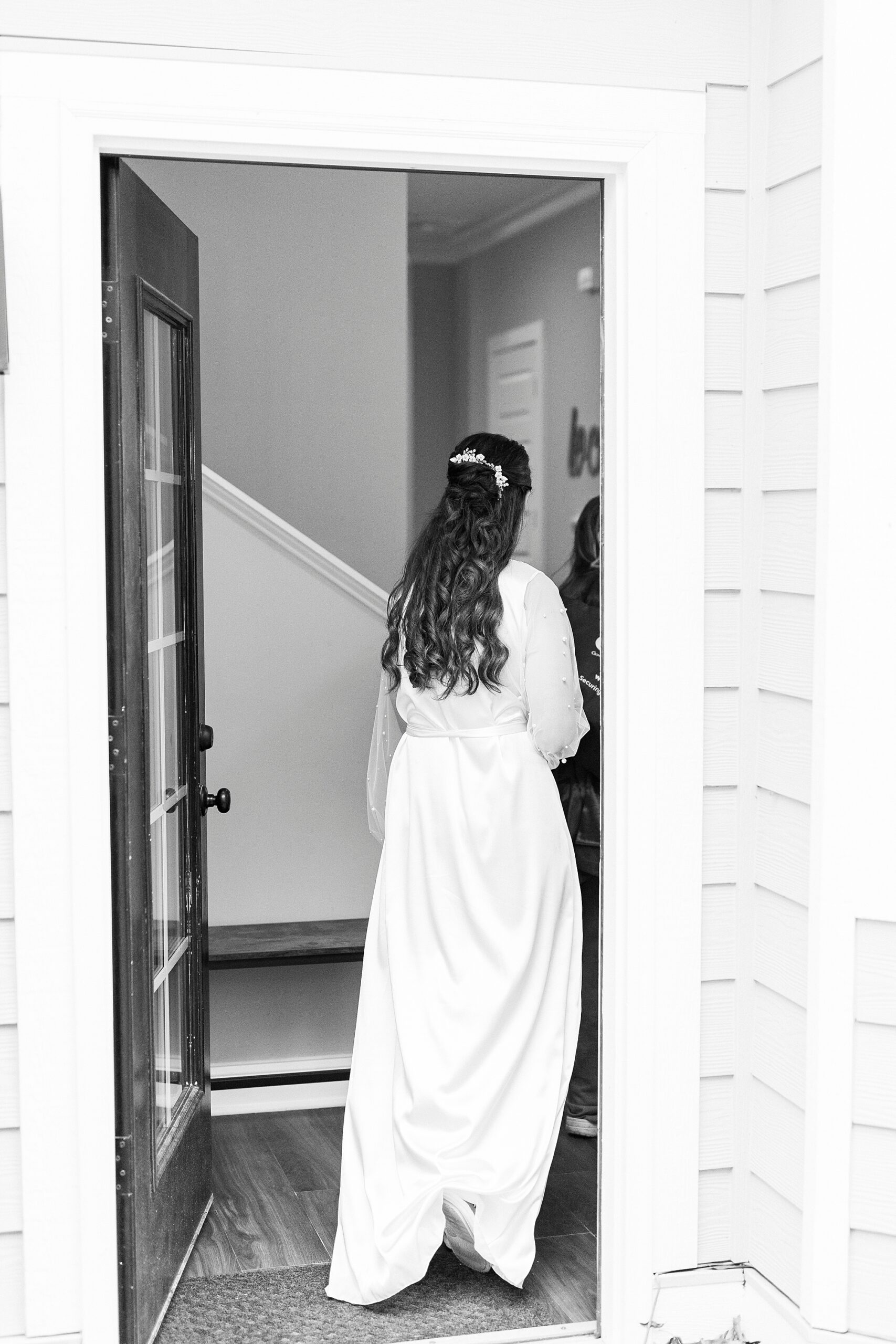 bride walks through NC home in long white robe on morning of wedding