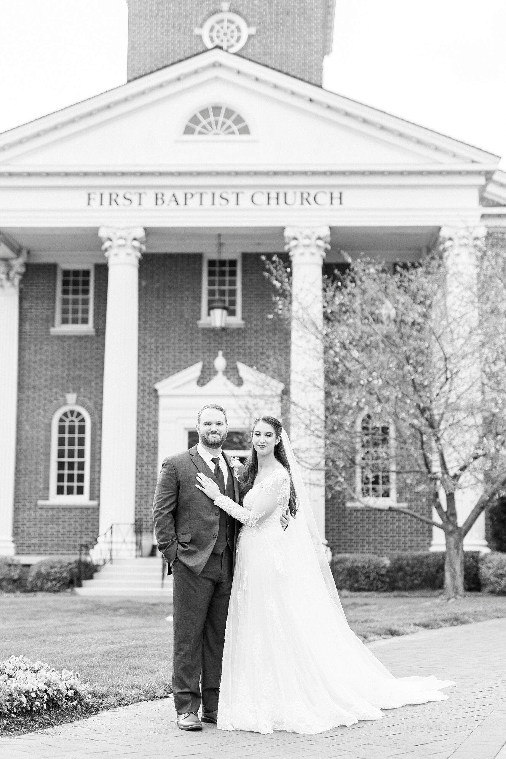 bride and groom stand outside First Baptist Church in Kannapolis NC