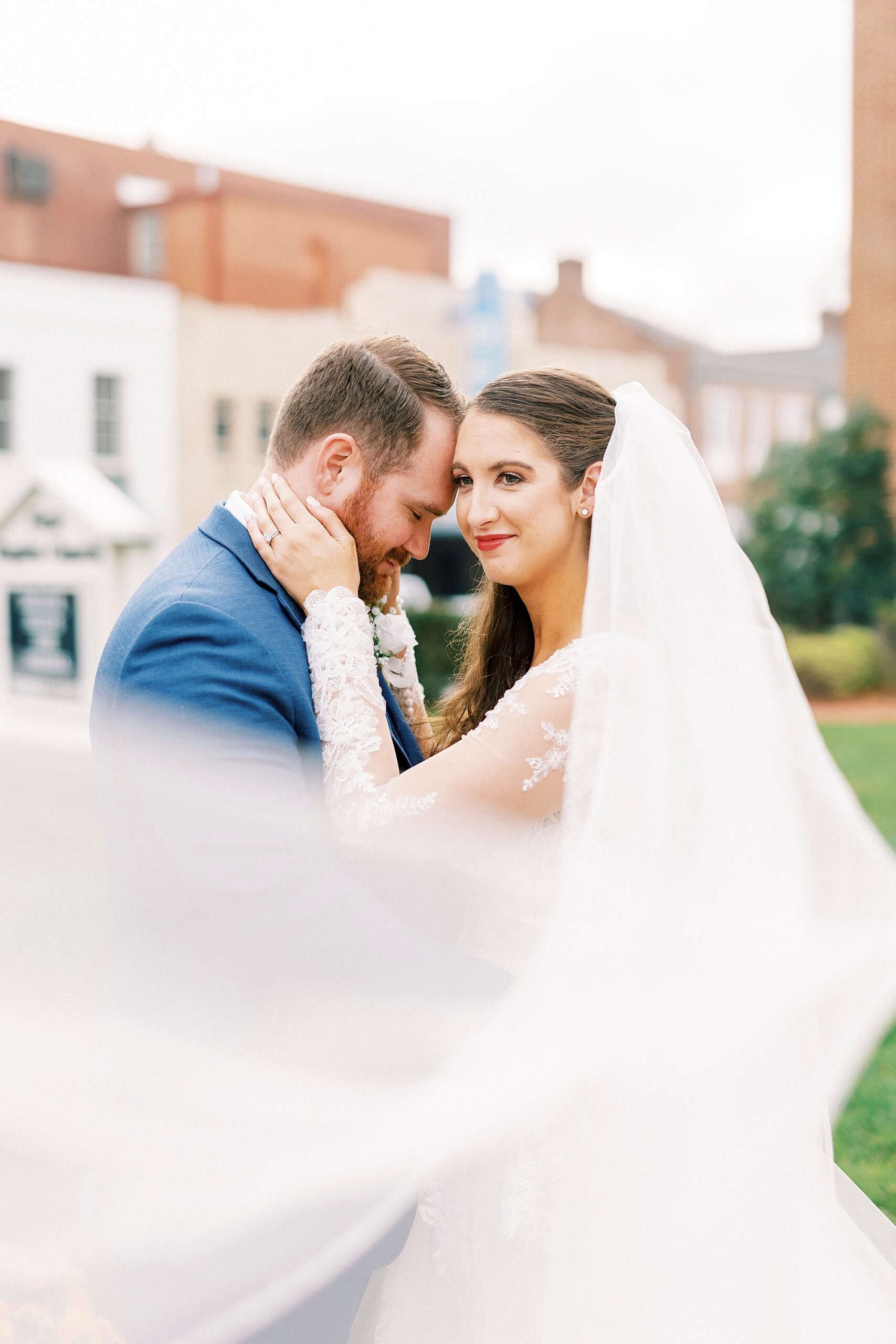groom leans into bride's forehead outside First Baptist Church in Kannapolis NC