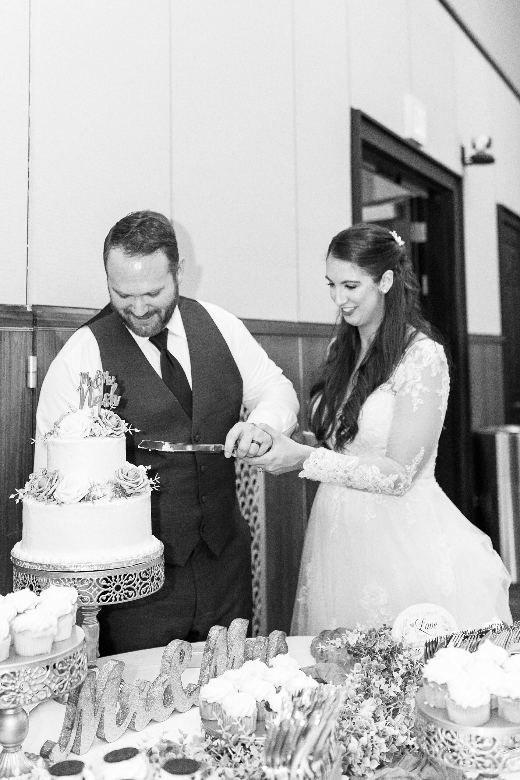 bride and groom cut wedding cake during reception
