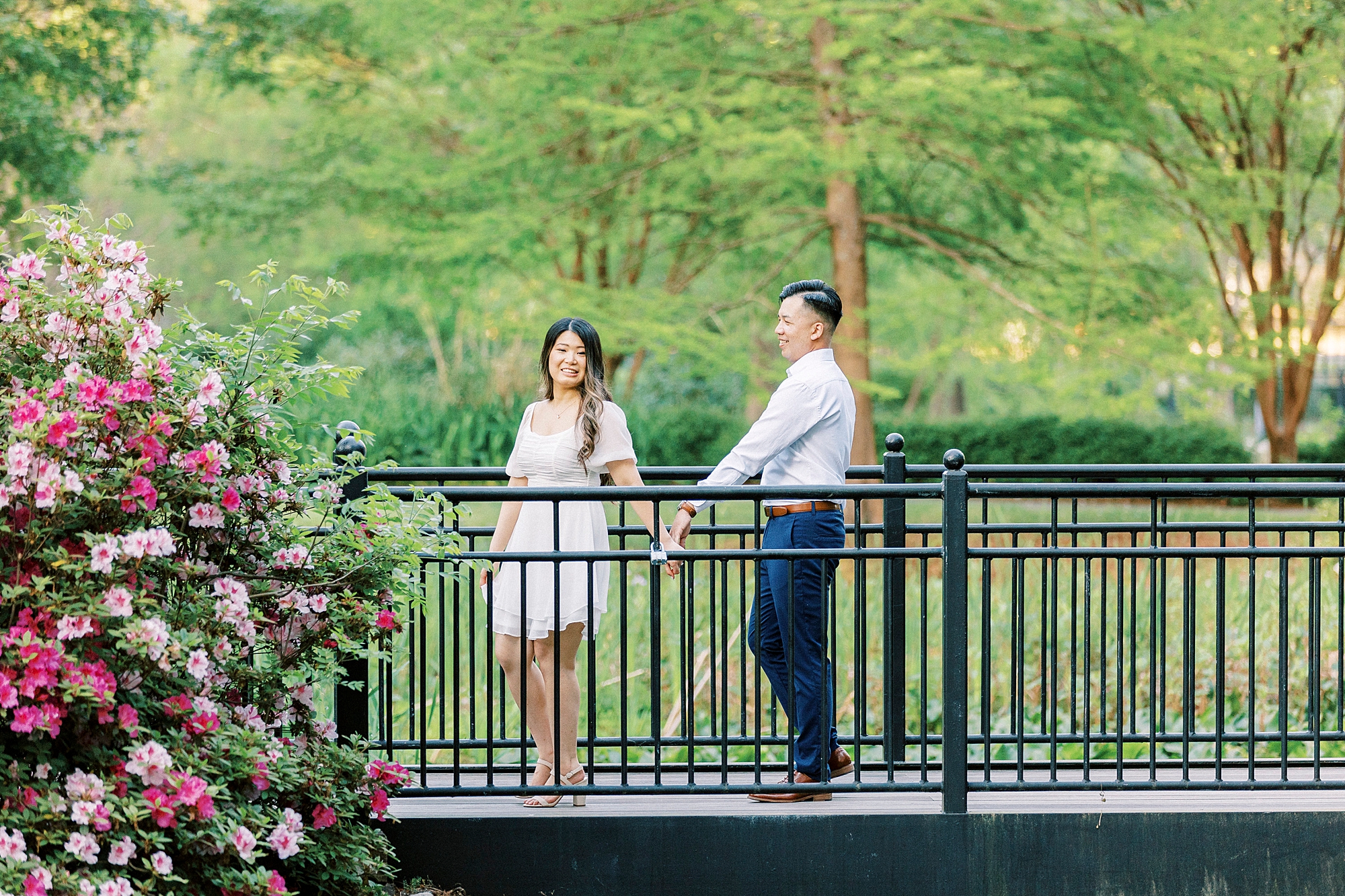 man and woman talk on metal bridge inside Glencairn Garden