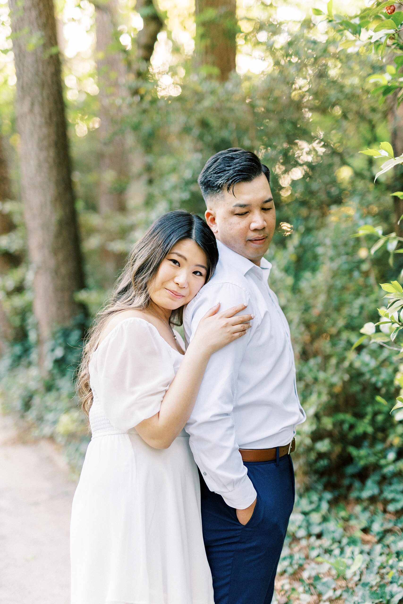 woman leans on man's back standing on pathway inside Glencairn Garden