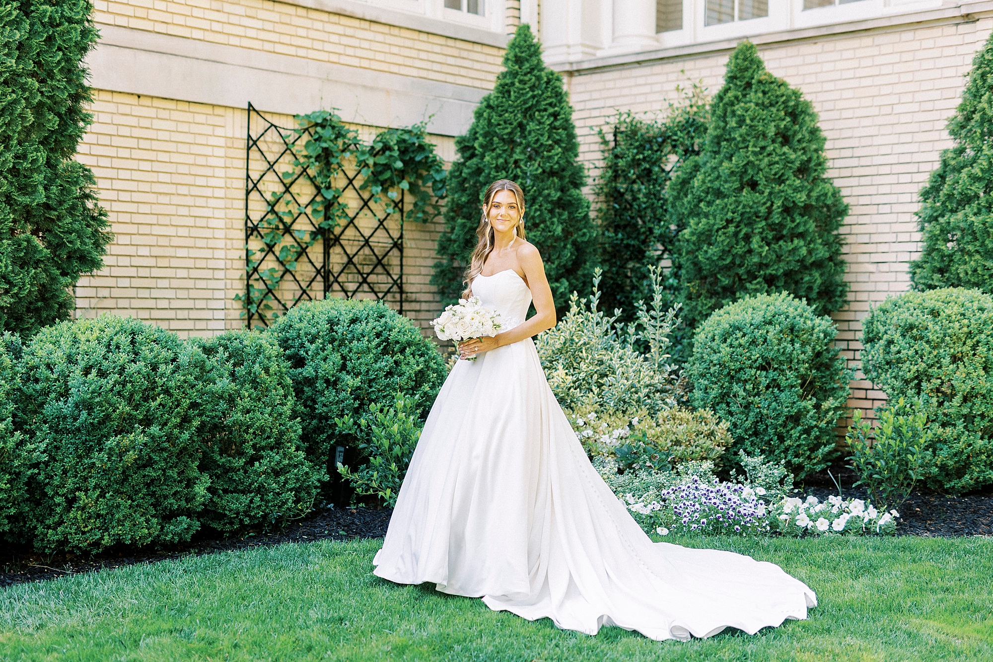 bride poses in front of bushes and shrubs at Separk Mansion