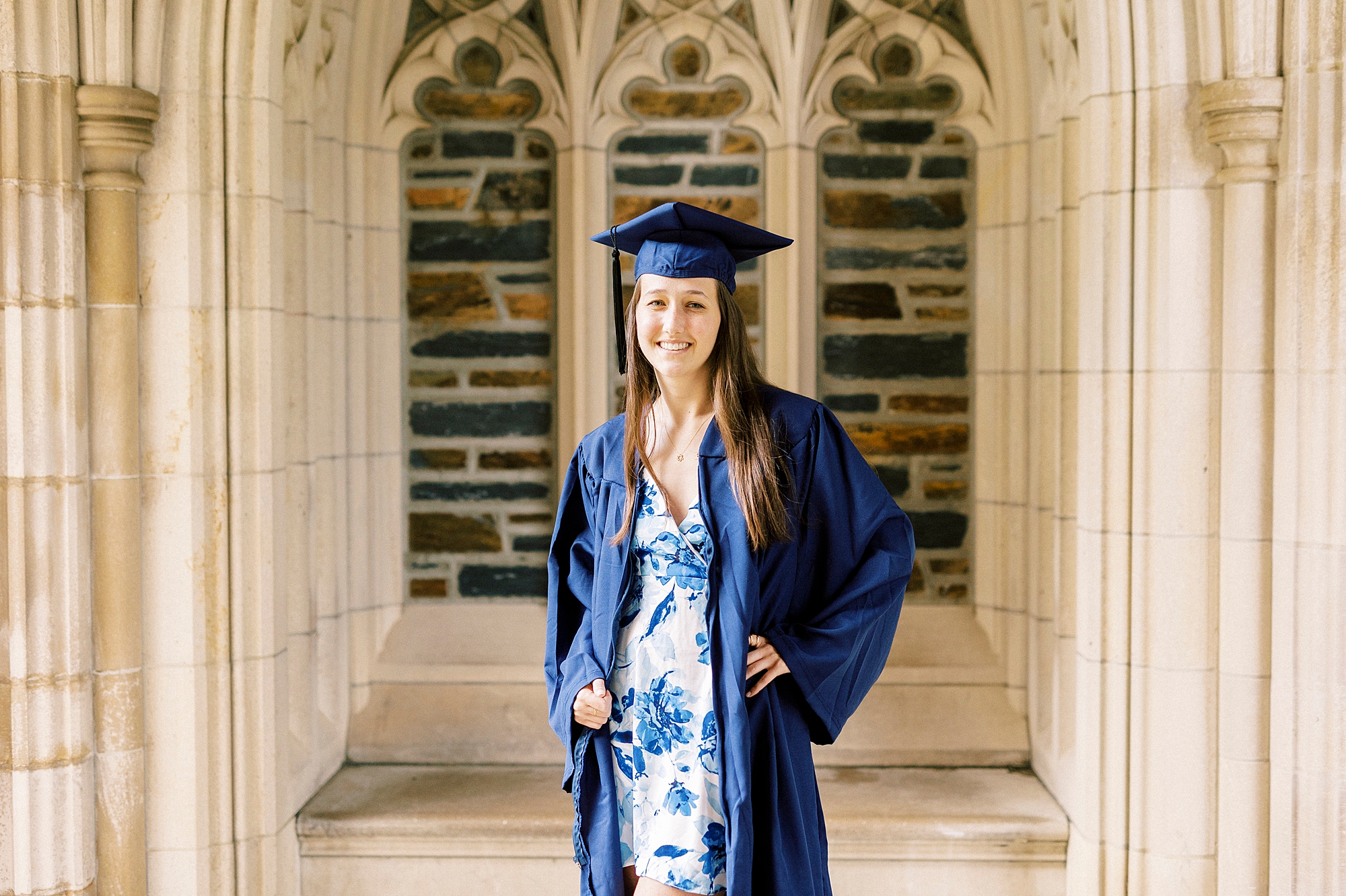 Duke University senior portraits for girl in blue and white flower dress with navy cap and gown