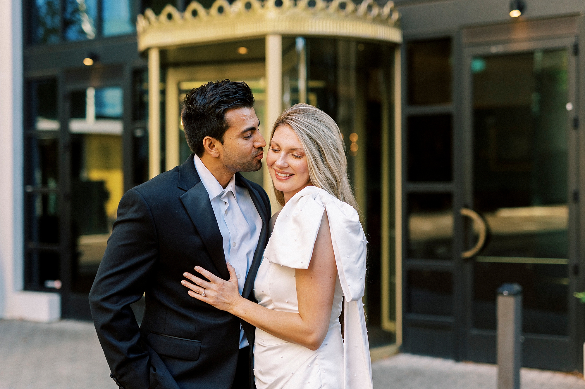 man leans to kiss woman on cheek outside the Grand Bohemian Hotel in Charlotte NC