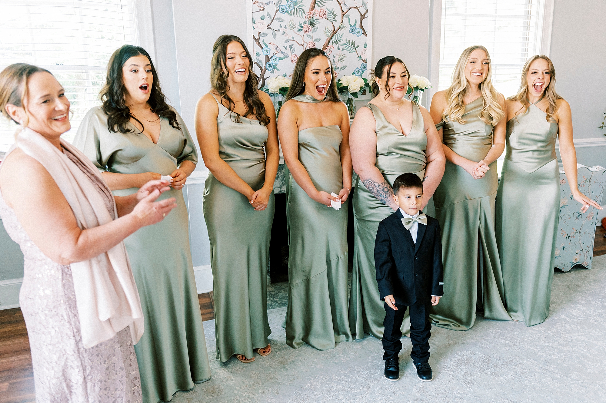 bridesmaids in sage green gowns have first look with bride