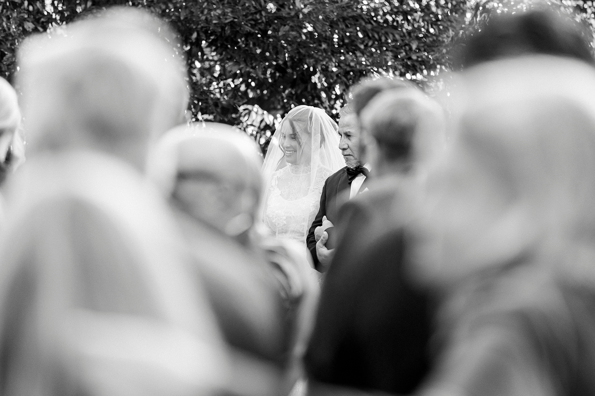 shot of bride walking down aisle between wedding guests