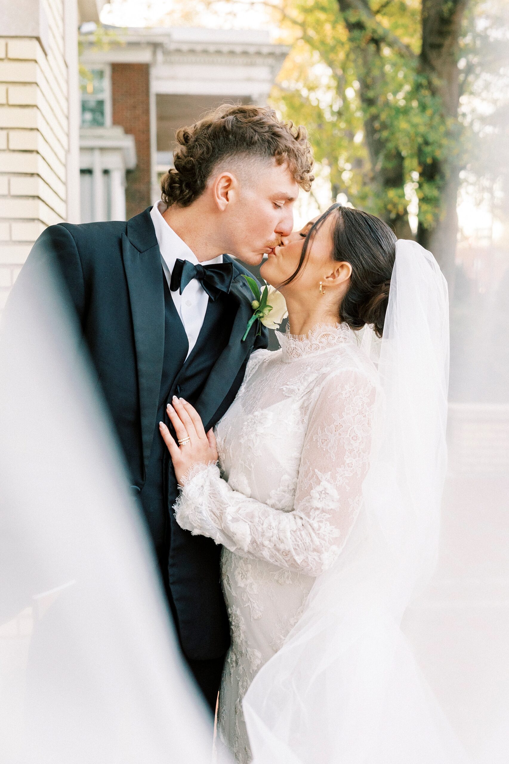 bride and groom kiss outside Separk Mansion with bride's veil pulled in front of them