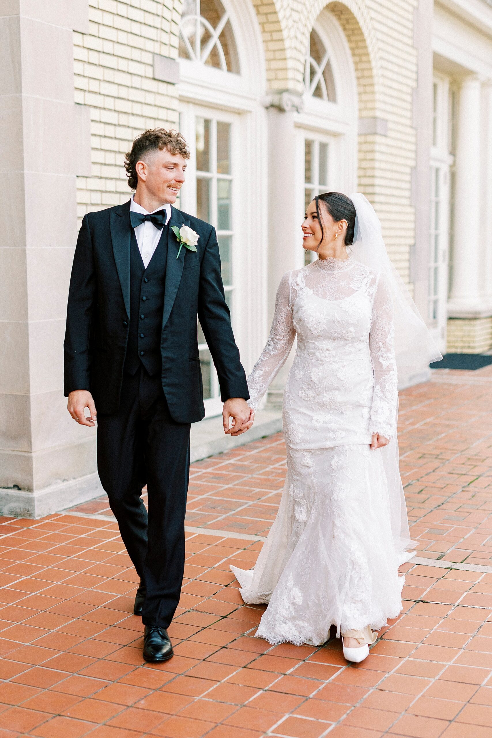 couple holds hands walking on patio at Separk Mansion