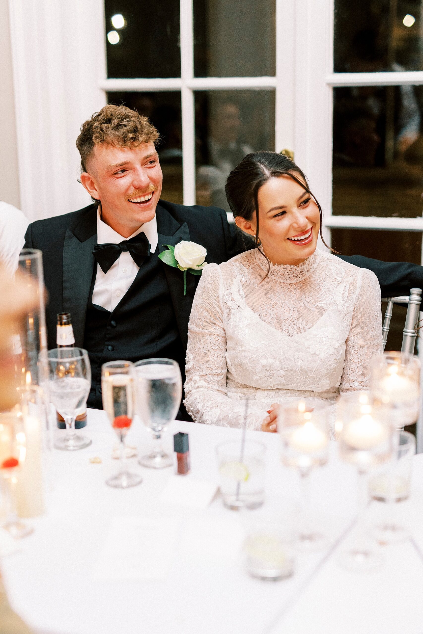 bride and groom smile hitting at table during reception at Separk Mansion